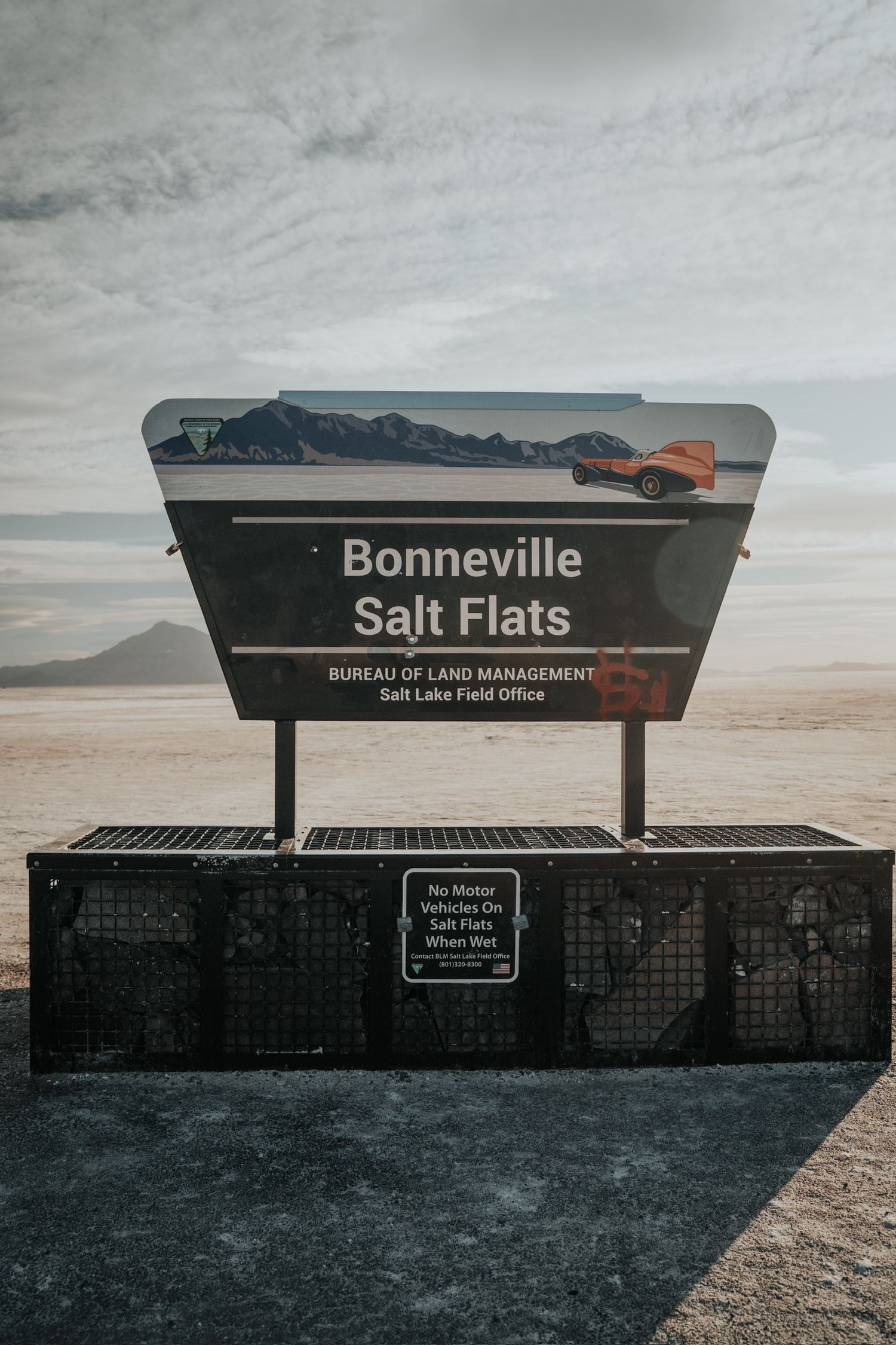 Bonneville Salt Flats entrance sign with informational panels under cloudy skies in Utah.