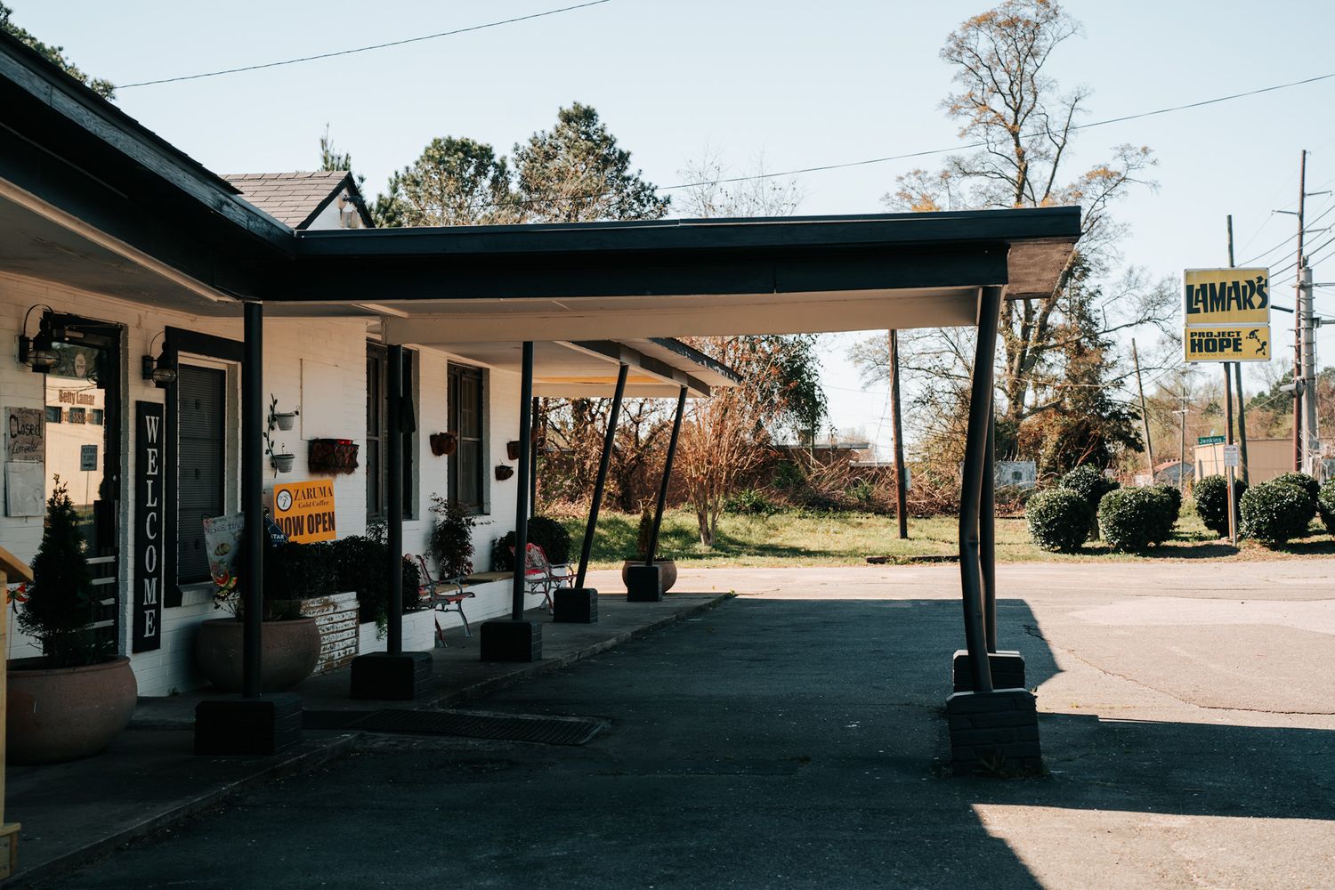 Vintage gas station canopy and storefront with empty fuel pumps on a sunny day.