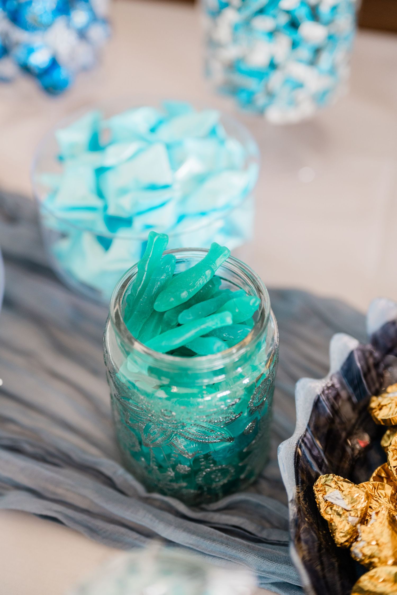 Shimmering turquoise and gold decorative elements arranged on a dark surface.