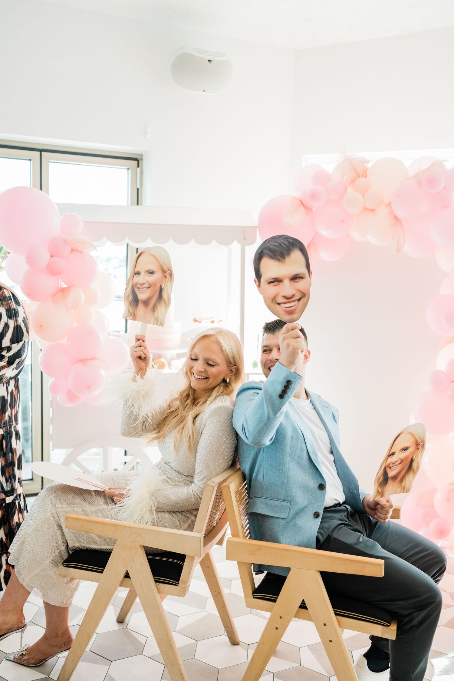 Pink balloon decorations create a festive atmosphere at an indoor celebration.