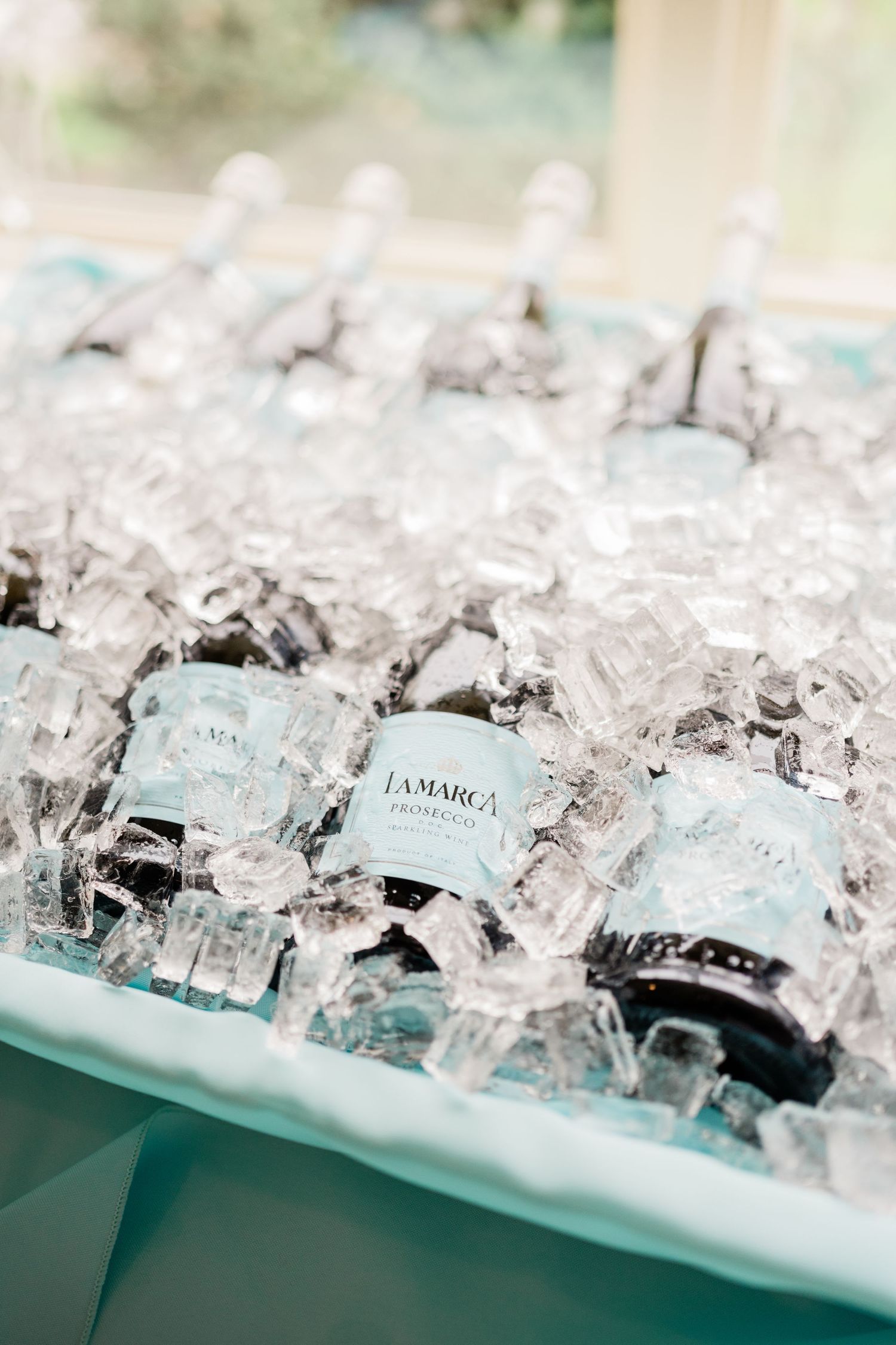 Bottles of La Marca prosecco chilling in crushed ice at an elegant event setup.
