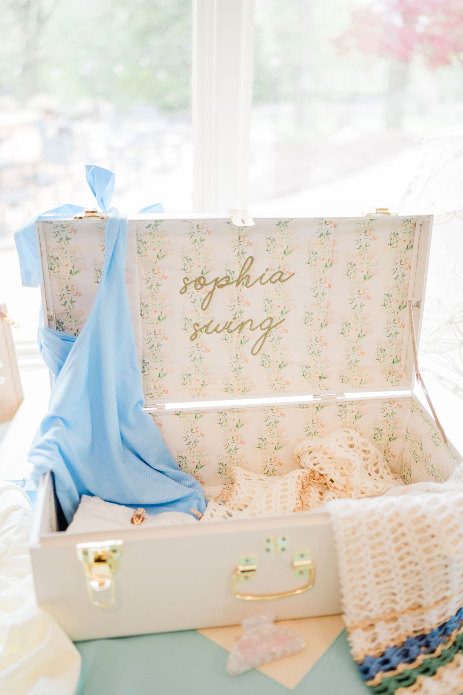 Wedding accessories and decorative items arranged with blue accents and gold lettering.