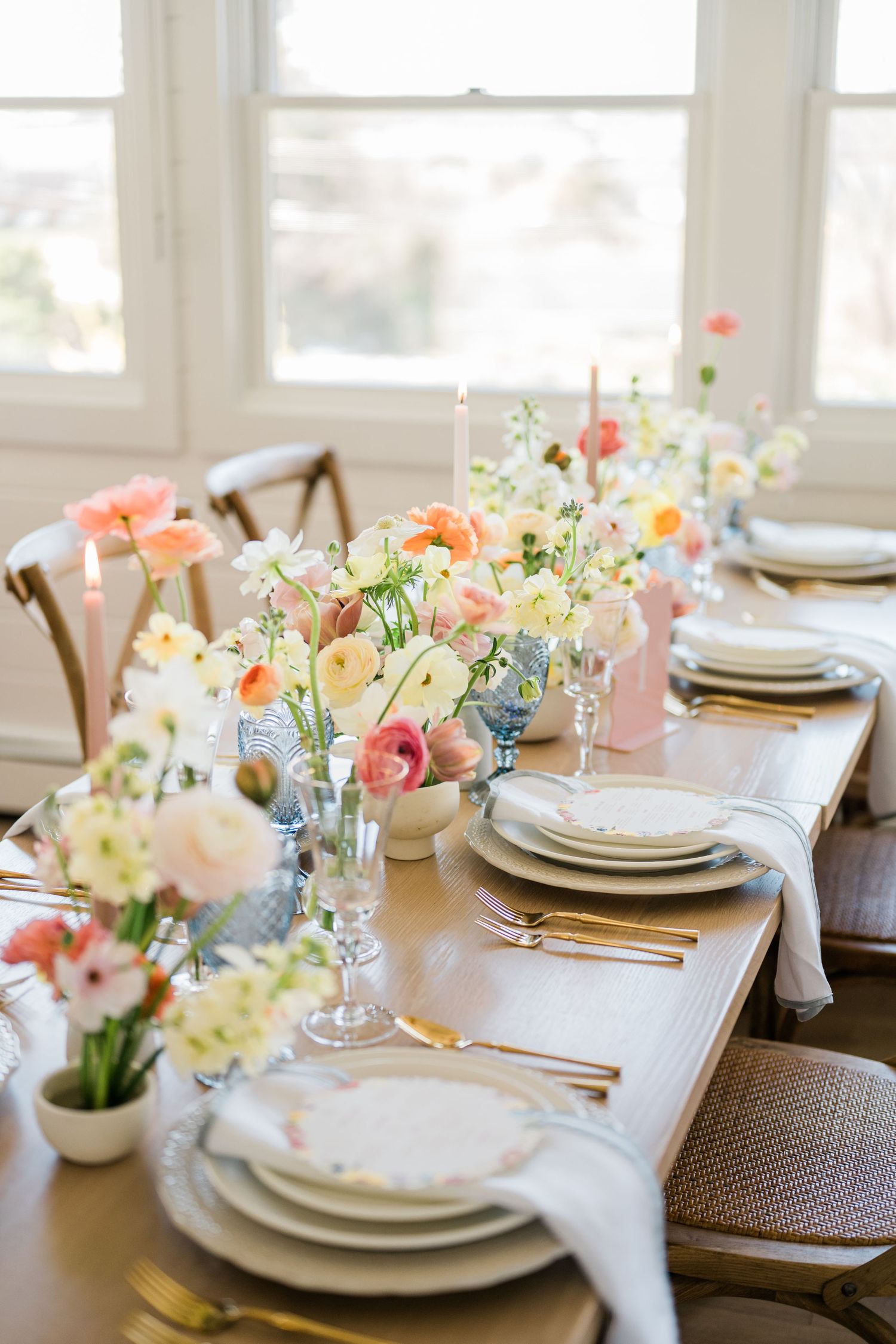 Elegant table setting with pastel flowers and white plates.