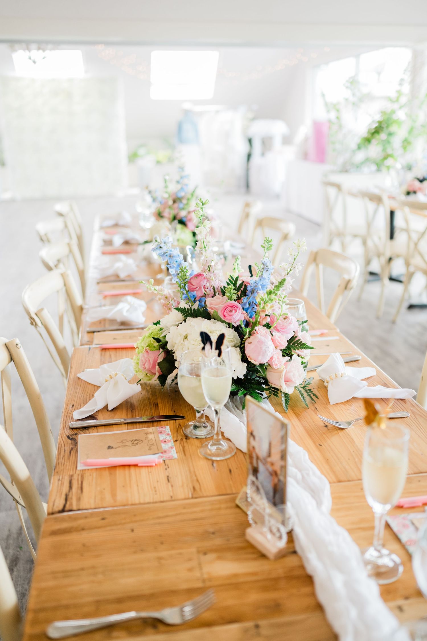 Wedding reception tables decorated with pastel floral arrangements and butterfly accents.