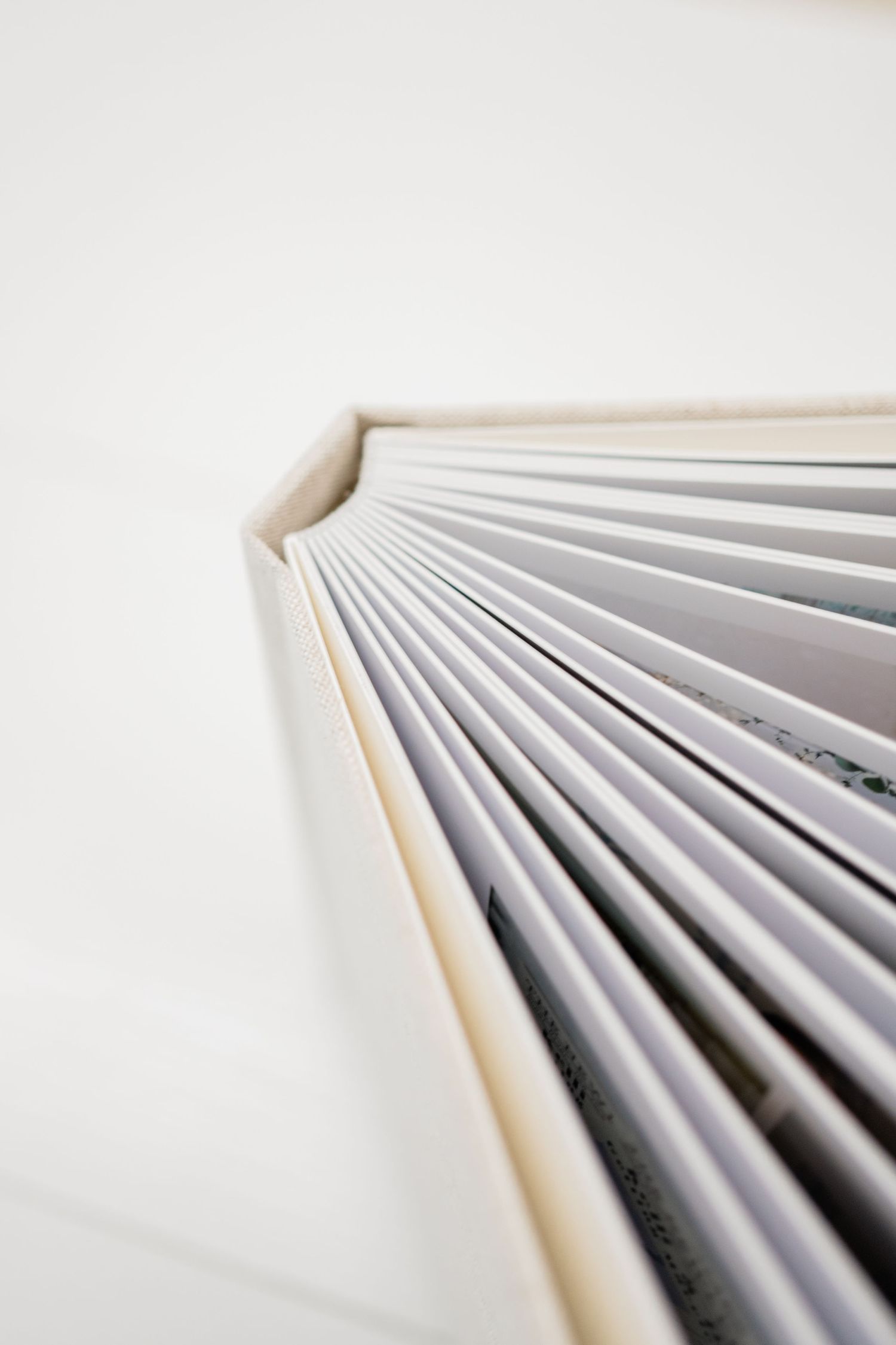 Close-up view of stacked white paper pages creating diagonal lines against white background.