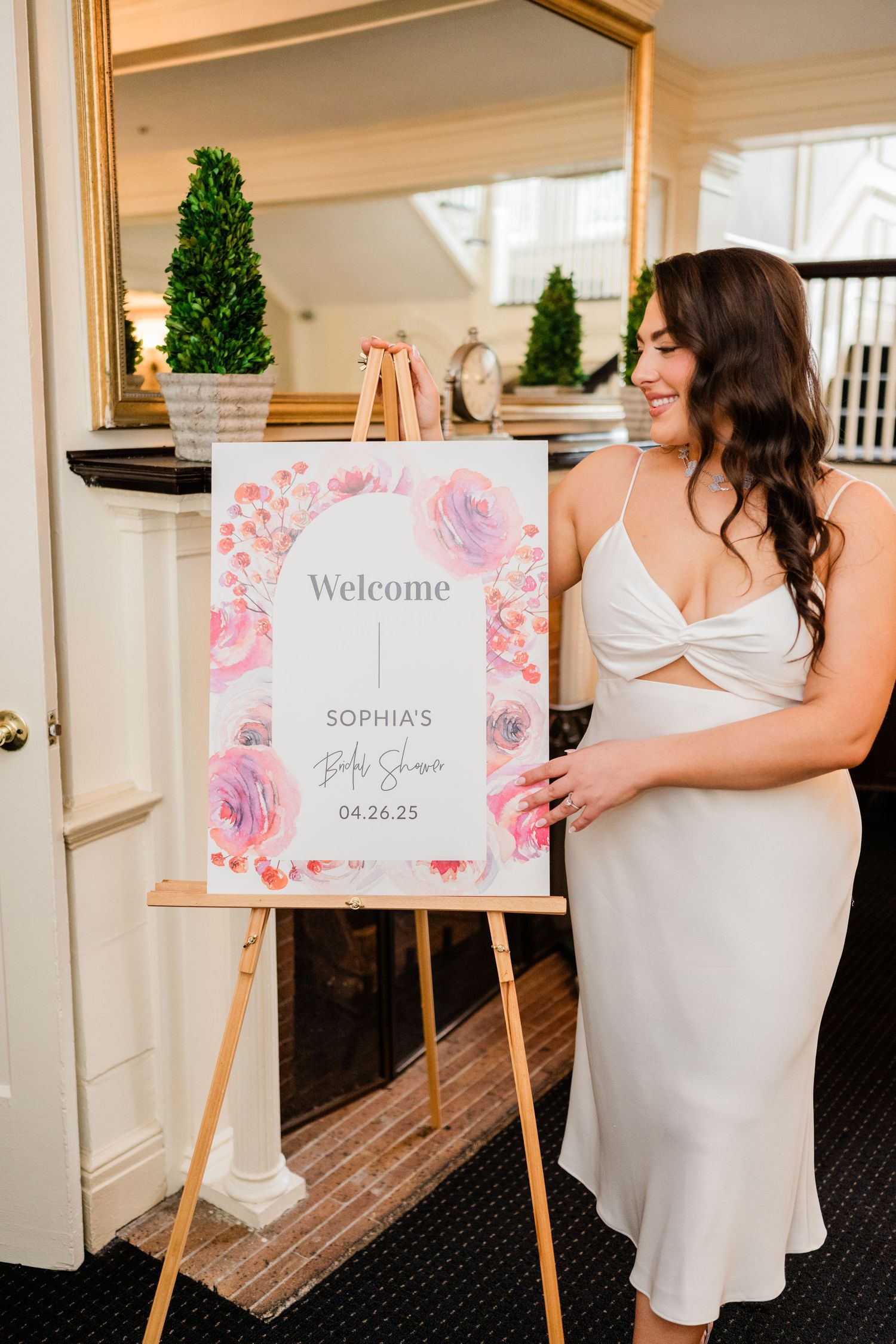 Wedding welcome signs with floral designs displayed on wooden easels.