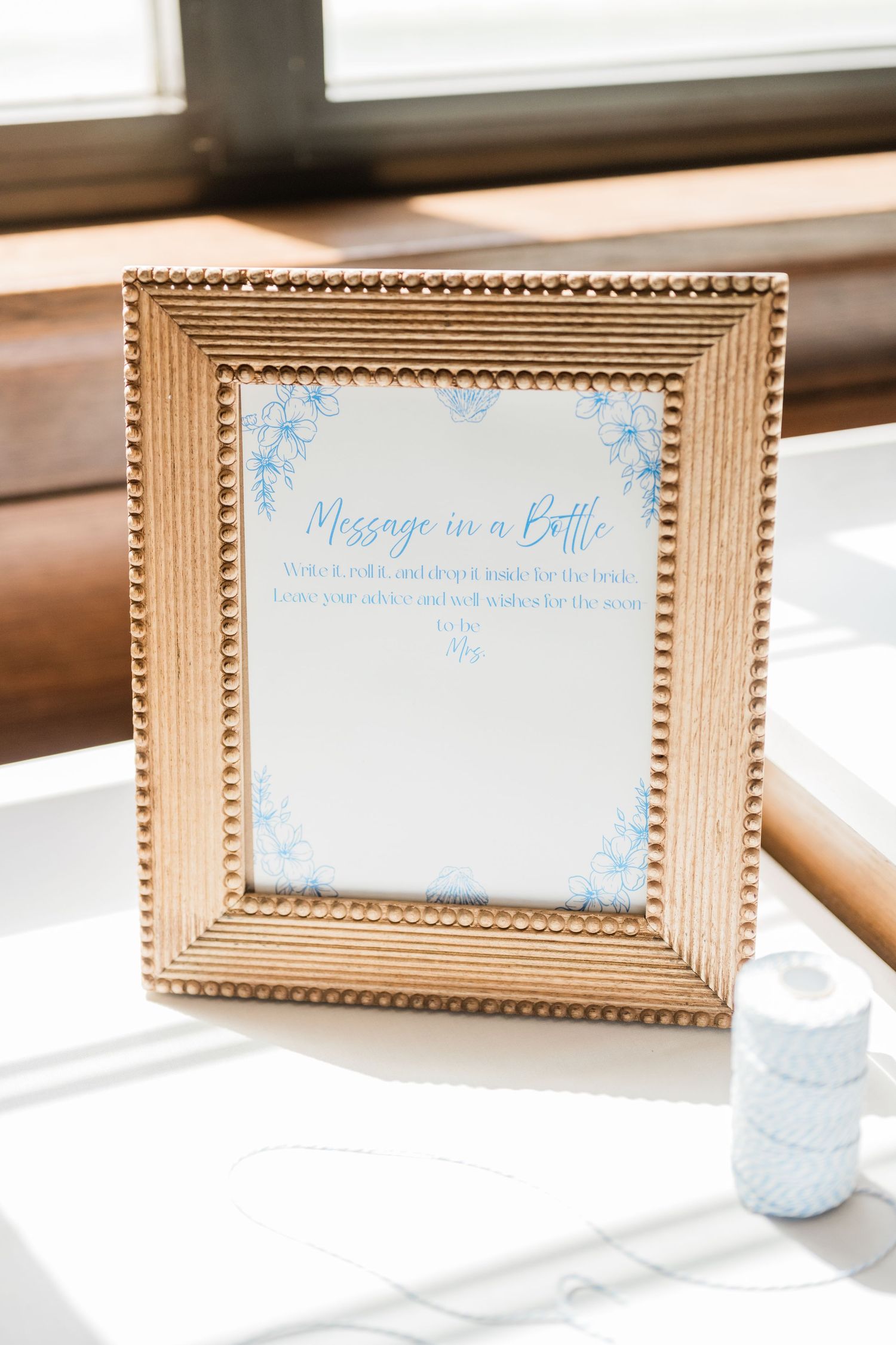 Gold-framed signs with blue text displayed on a white surface for an elegant event.
