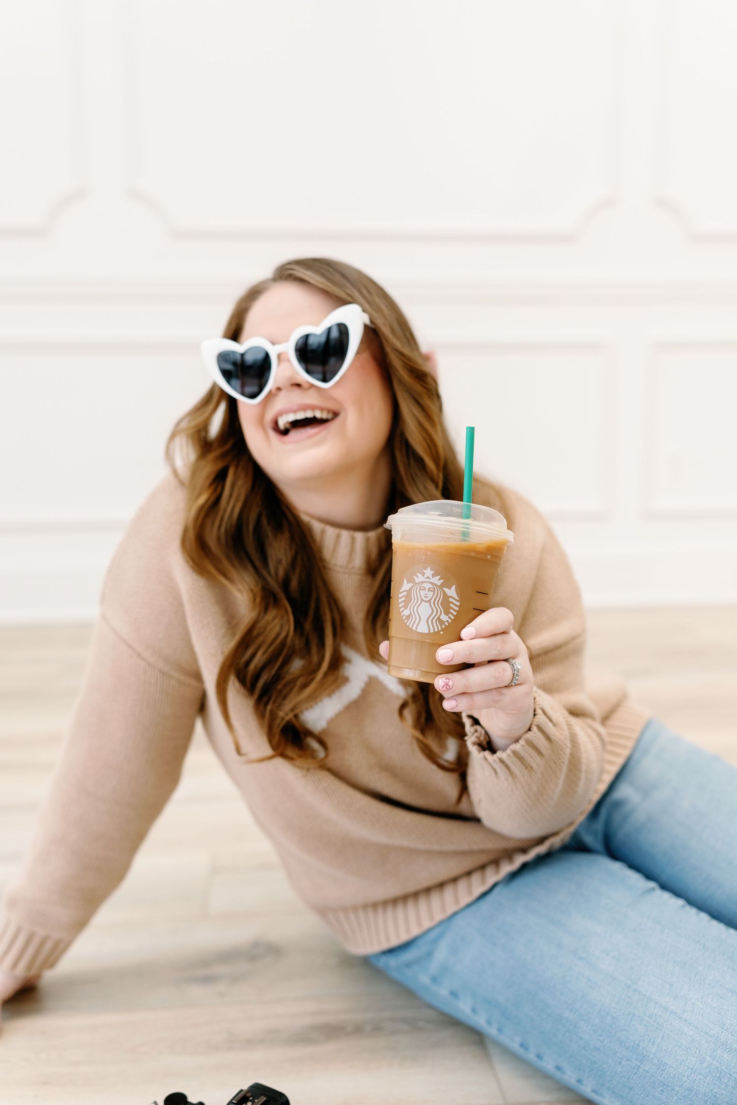 Casual portrait with heart-shaped sunglasses and Starbucks drink.