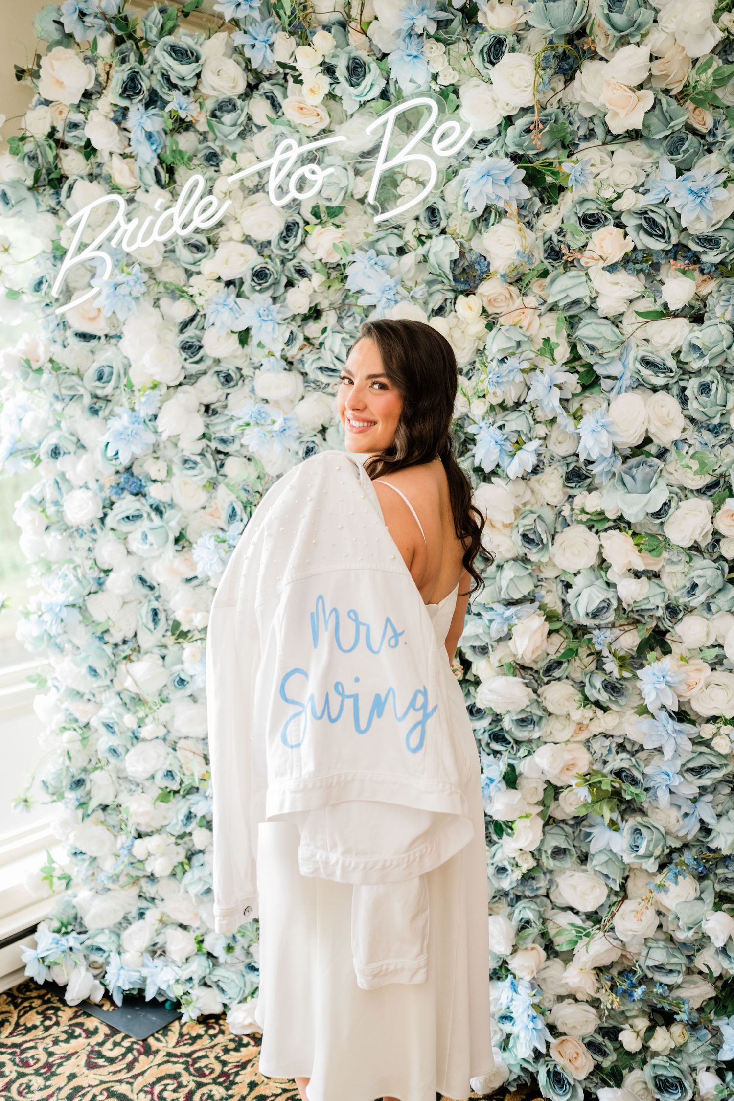 Bridal robe photo against a luxurious blue and white floral backdrop.