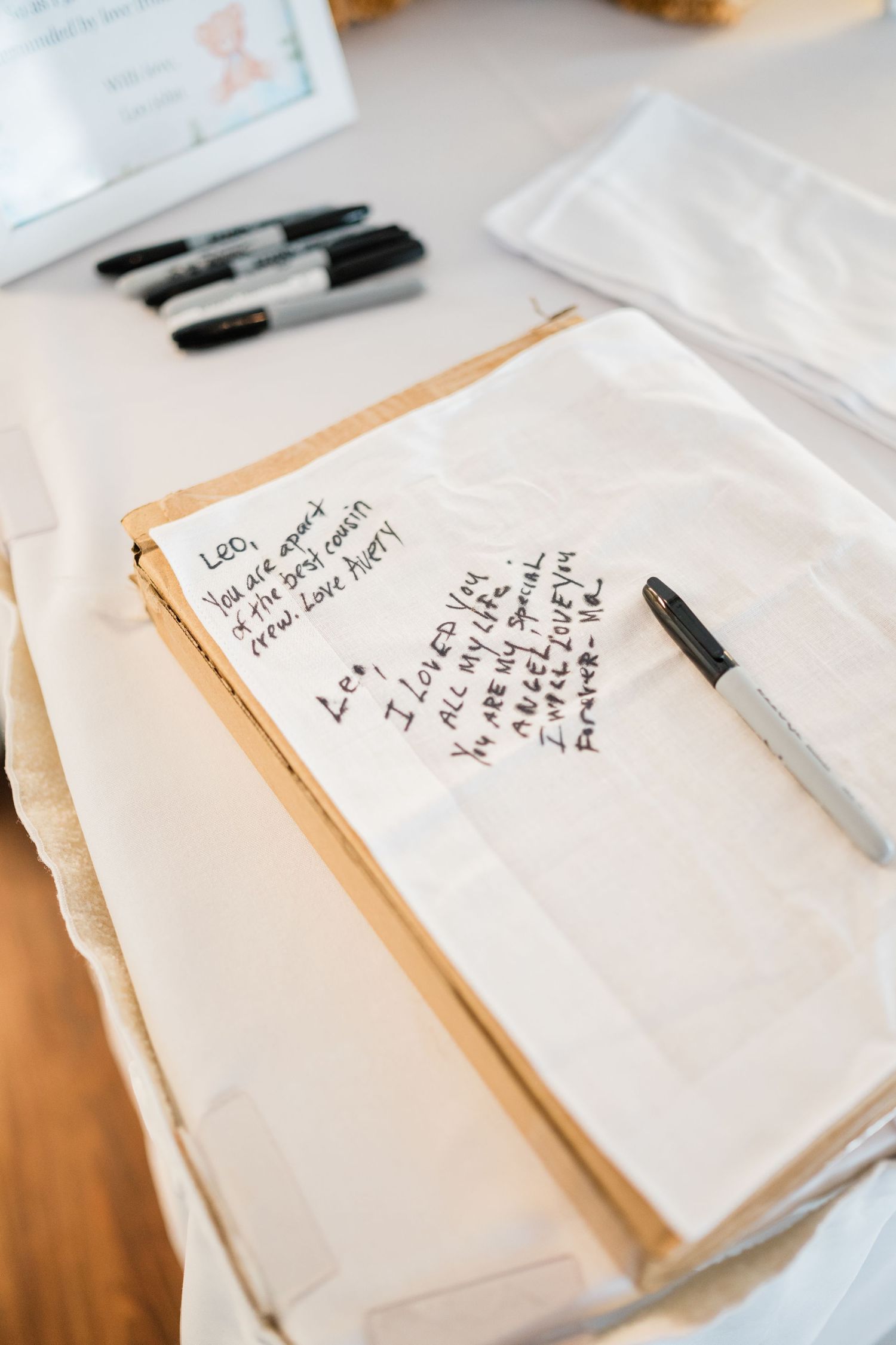 Handwritten notes and papers laid out on a white surface with black pens.