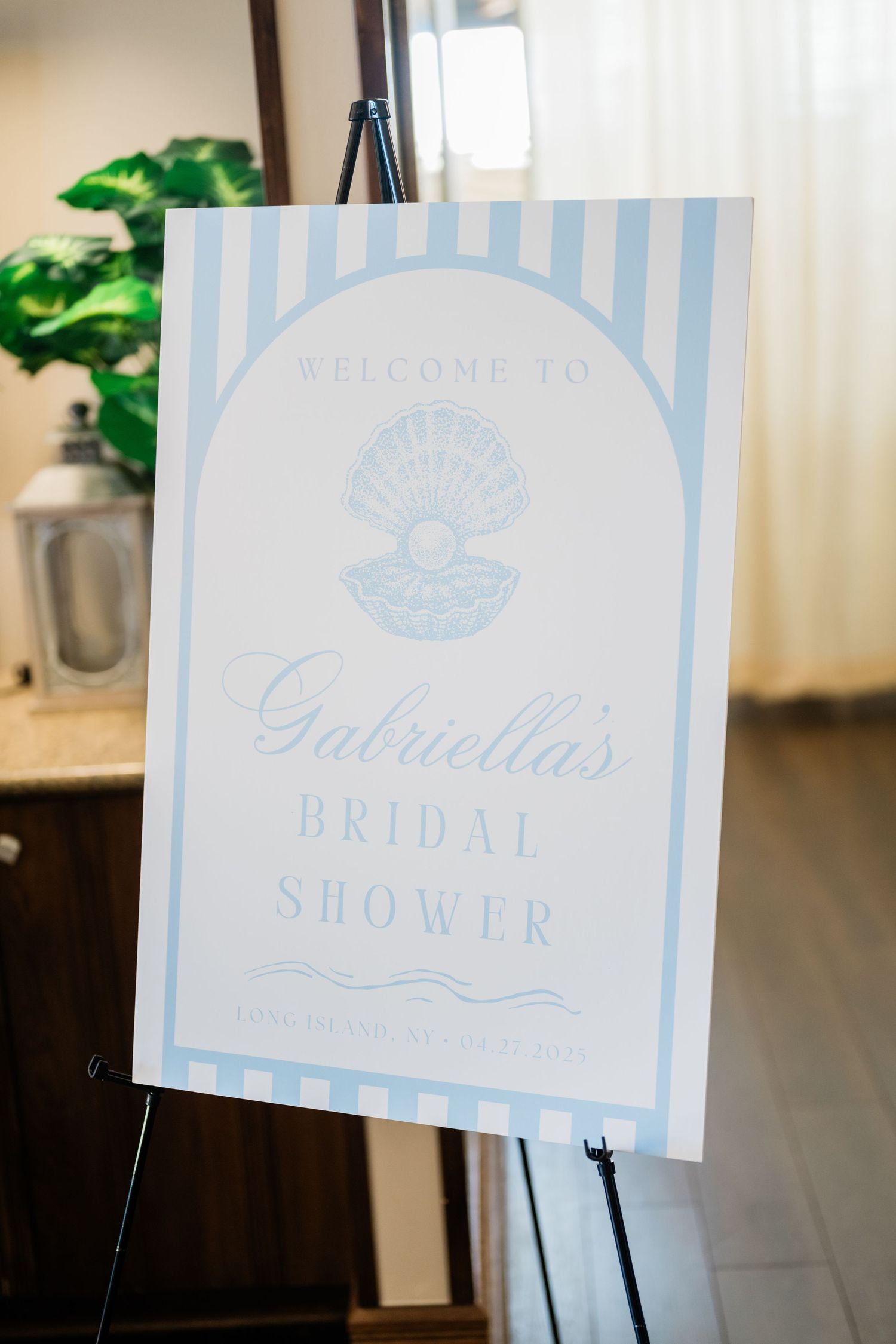 Light blue and white striped welcome signs displayed on easels at an event.