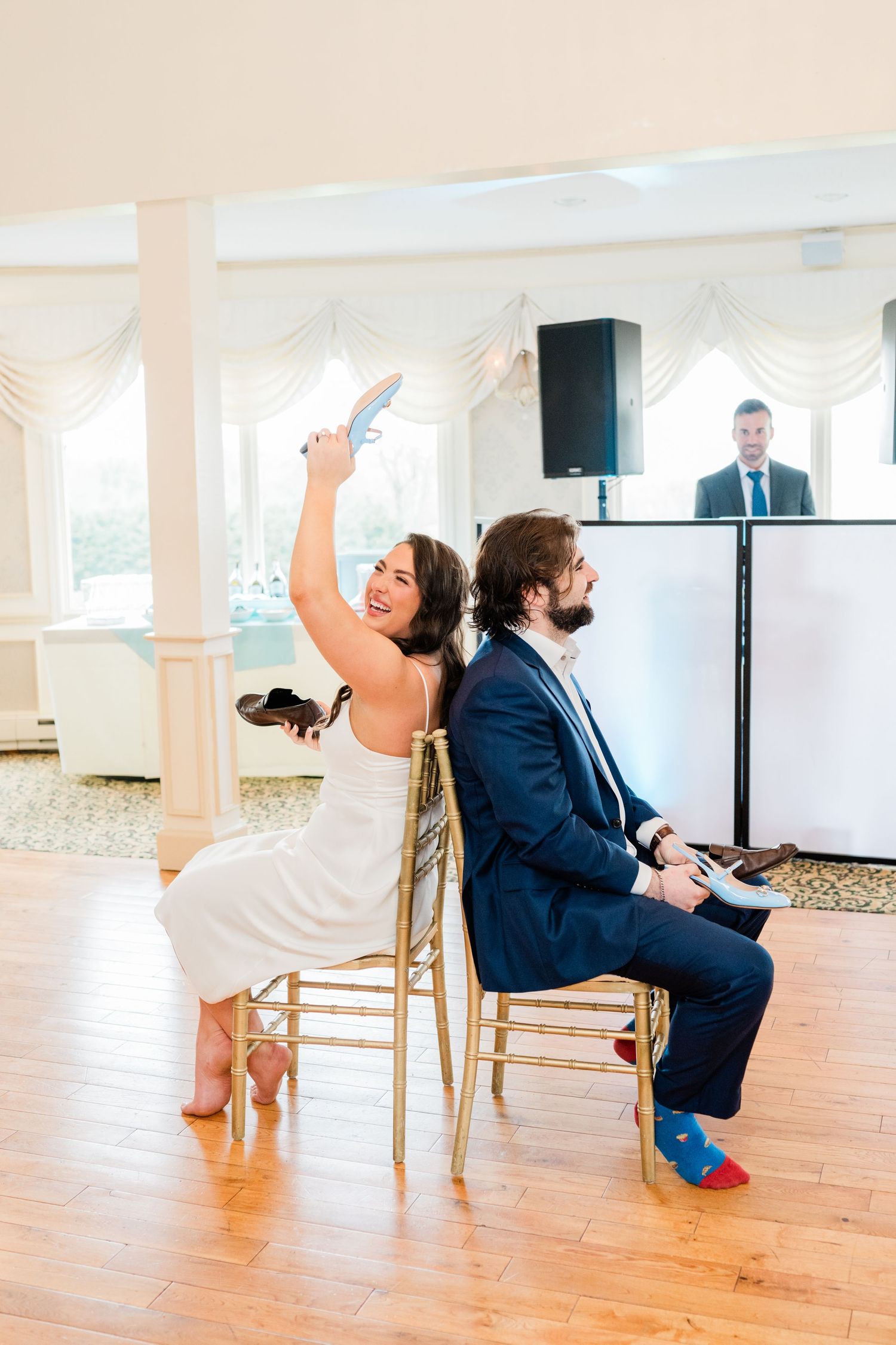 Wedding guests playing a fun game with chairs in an elegant reception hall.