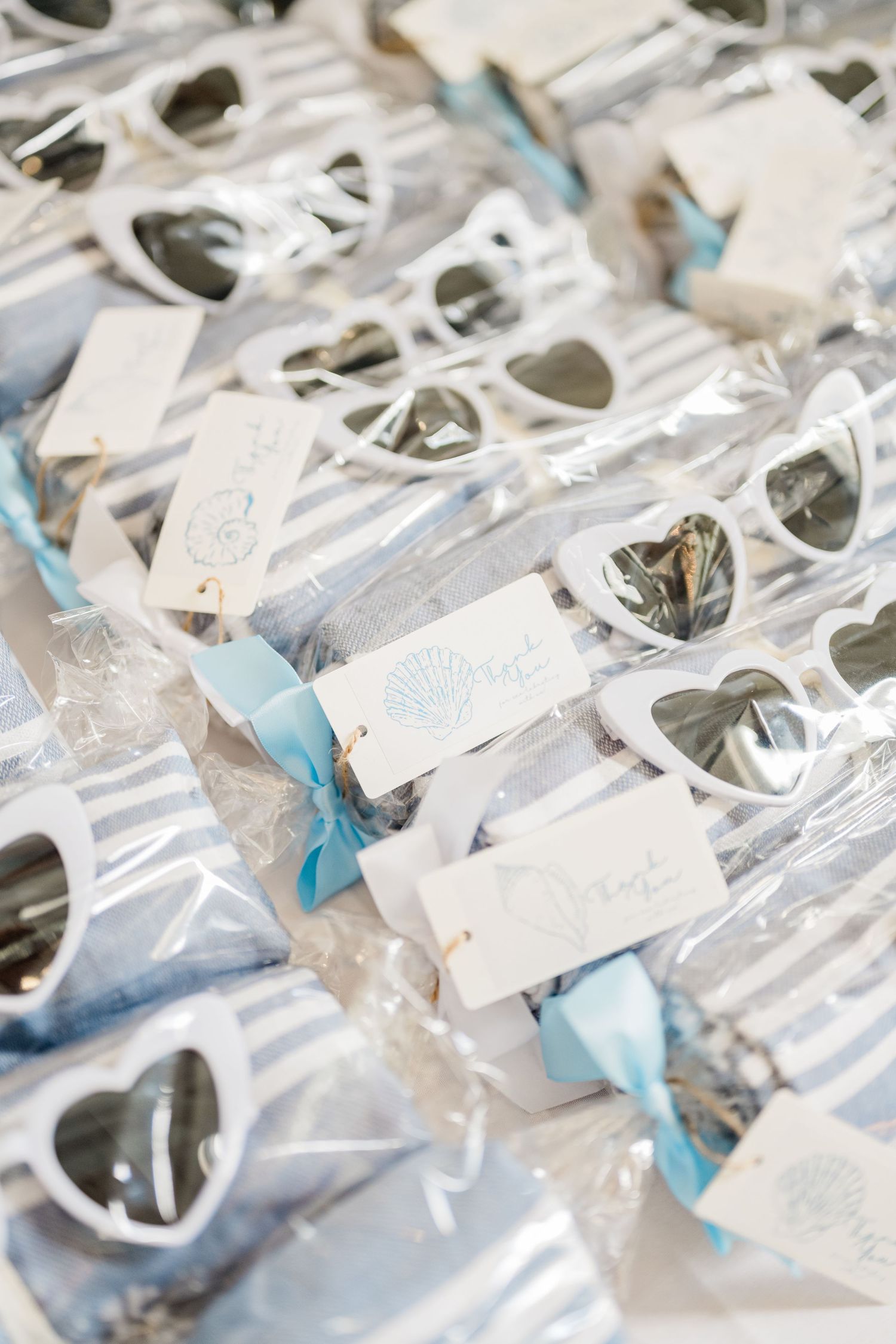 Row of wrapped party favors with light blue ribbons and white tags arranged neatly.