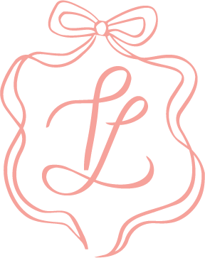 Elegant pink monogram logo with cursive letter L inside a decorative frame topped with a ribbon bow.