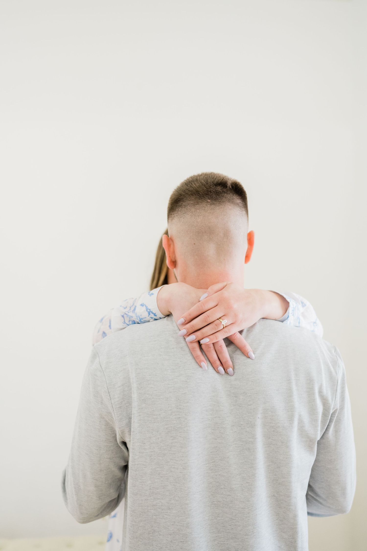 Back view portrait series showing hands placed on grey shirt.