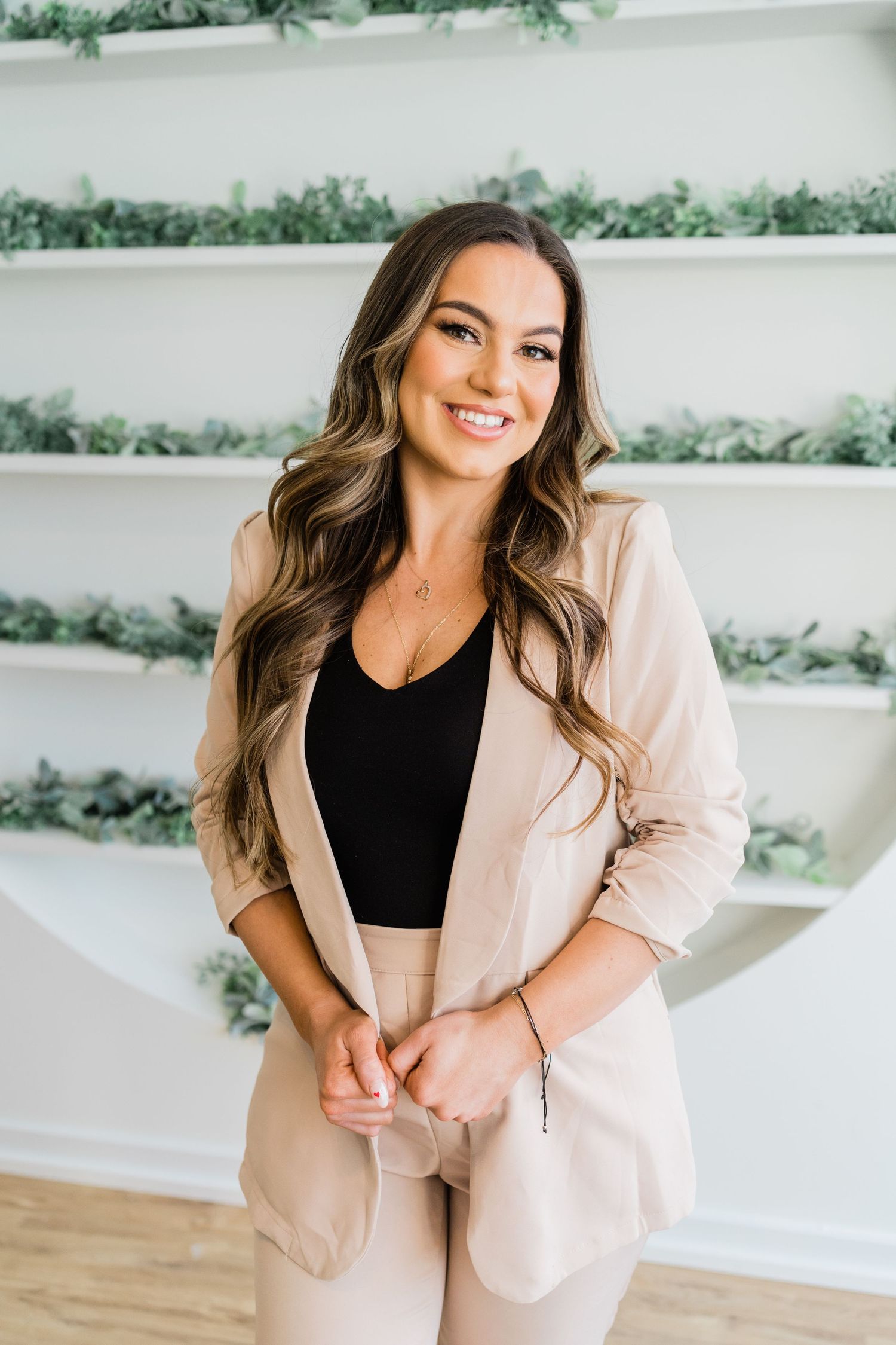 Lifestyle branding photos in a bright studio space with beige suit and black top.