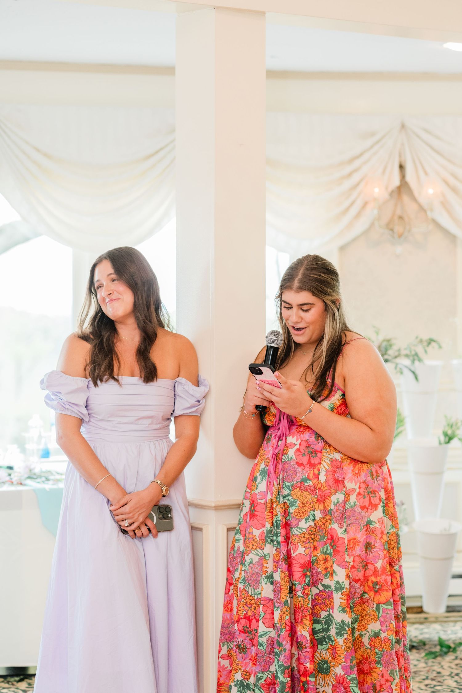 Wedding party members share candid laughing moments in a bright venue space.