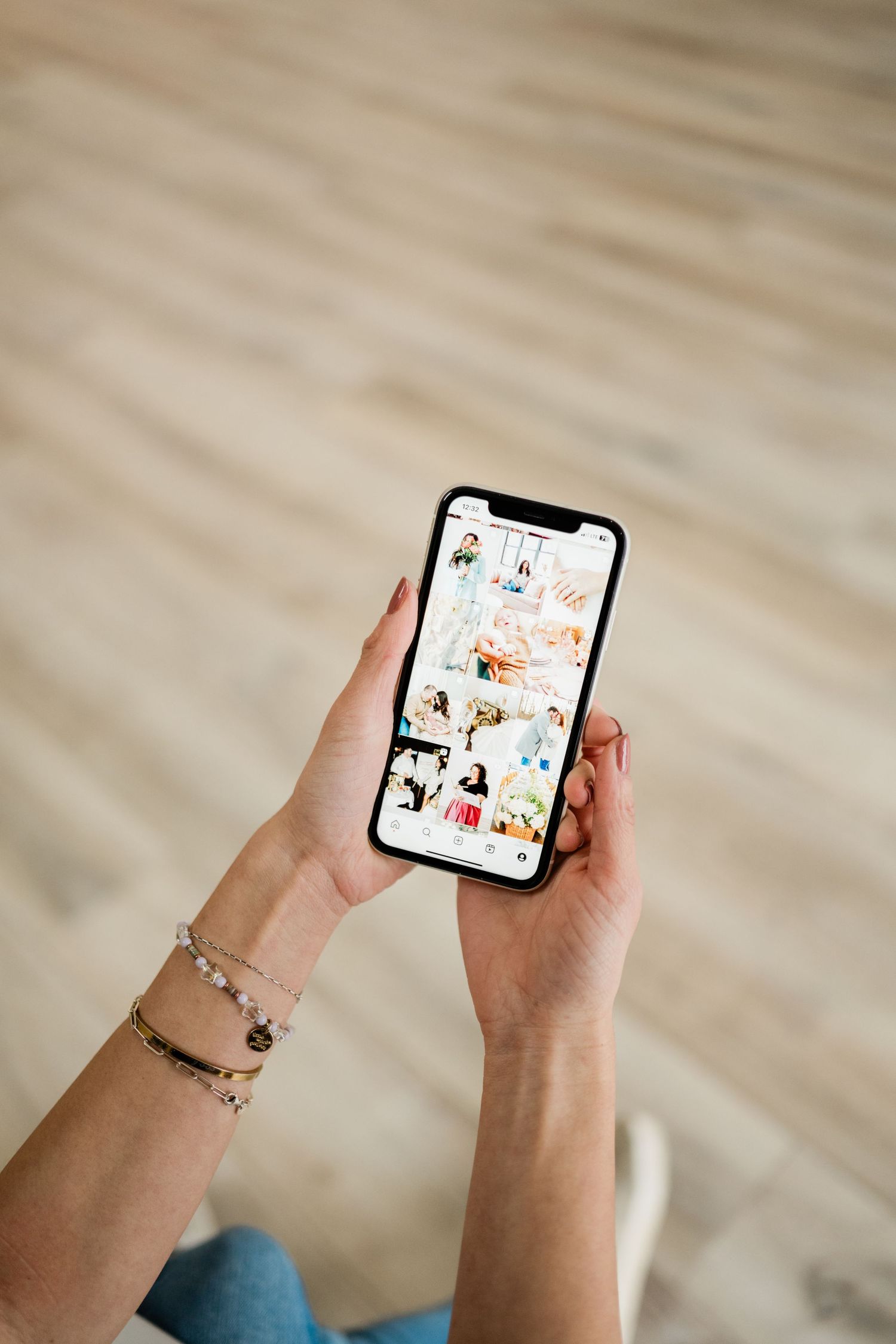 Person scrolling through photos on a smartphone while wearing a bracelet.