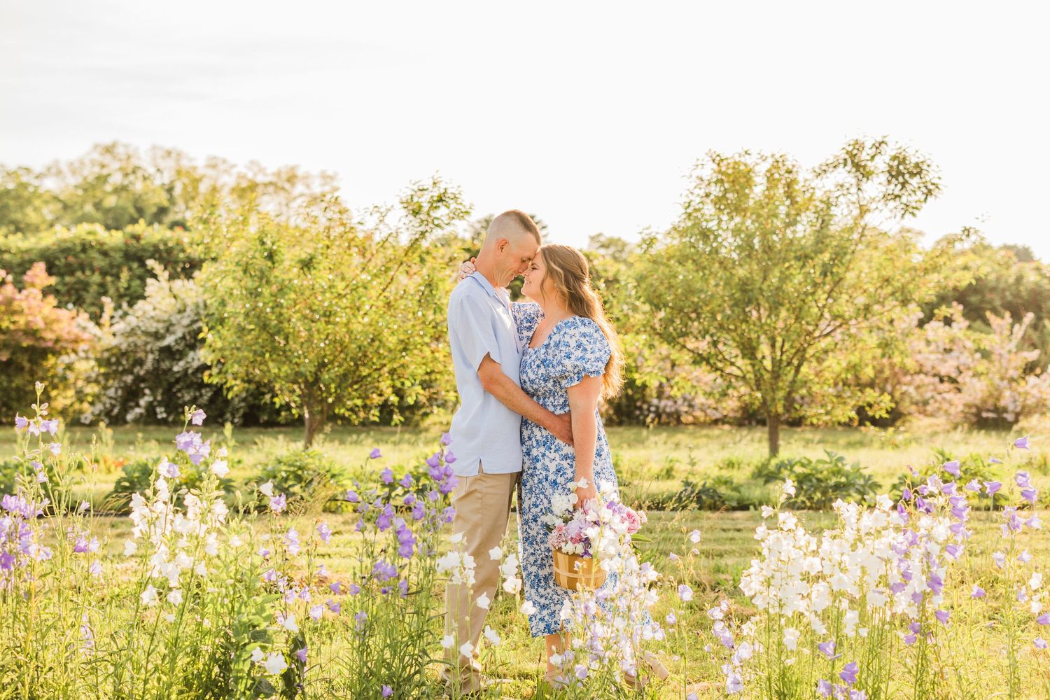 Romantic portraits in blooming flower field during golden hour.