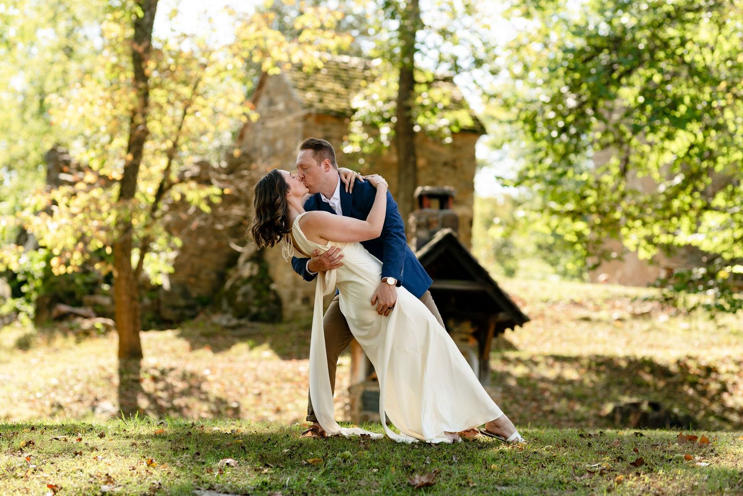 A groom dips his bride in front of a rustic historical building in Glenn Mills PA