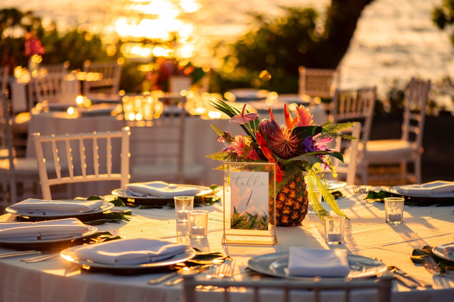 Elegant outdoor wedding reception table setting with floral centerpiece at Mauna Kea Resort Hawaii.