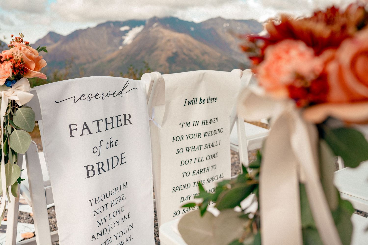 Reserved Father of the Bride wedding ceremony chair sign with mountain backdrop and floral arrangements.