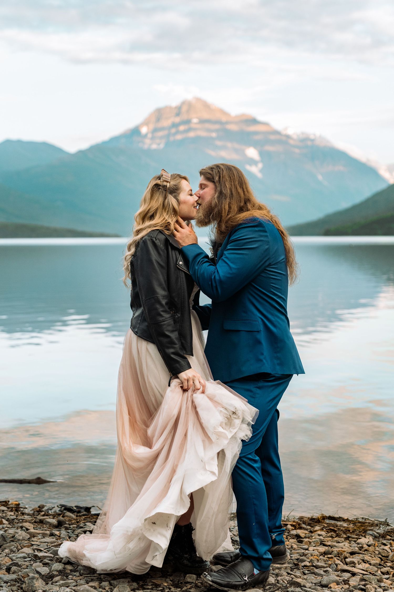A romantic wedding portrait against a stunning mountain lake backdrop.
