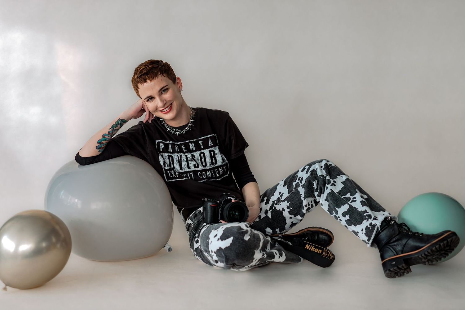 Young person relaxing with balloons wearing Star Wars themed clothing.