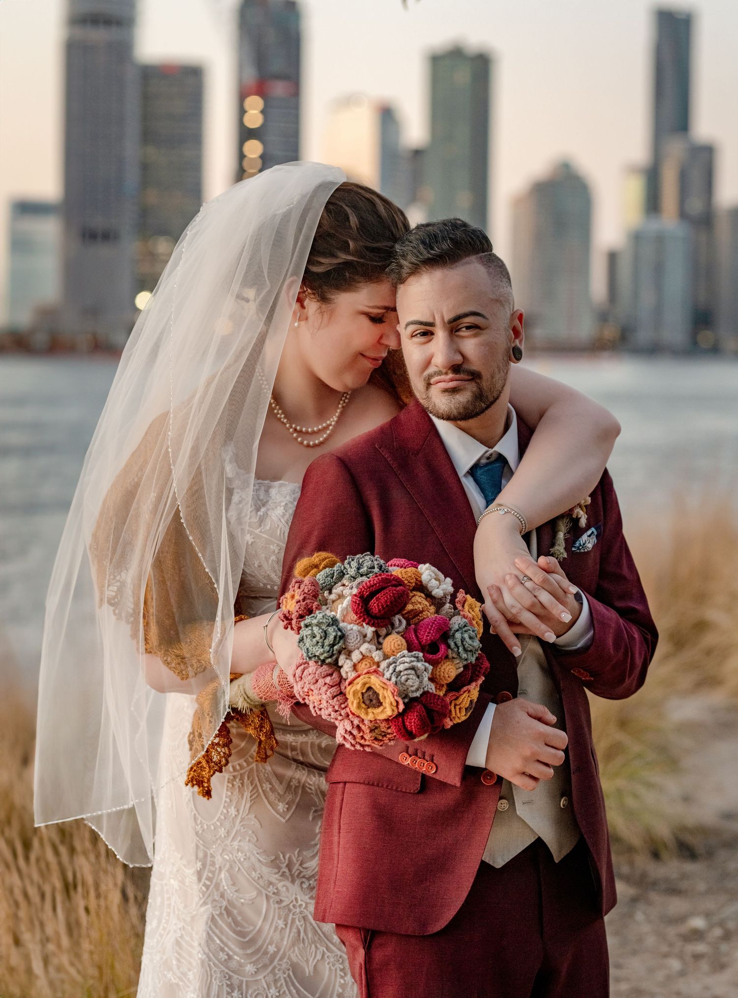 A wedding couple embraces against city skyline as bride holds vibrant floral bouquet in Brisbane, AUS