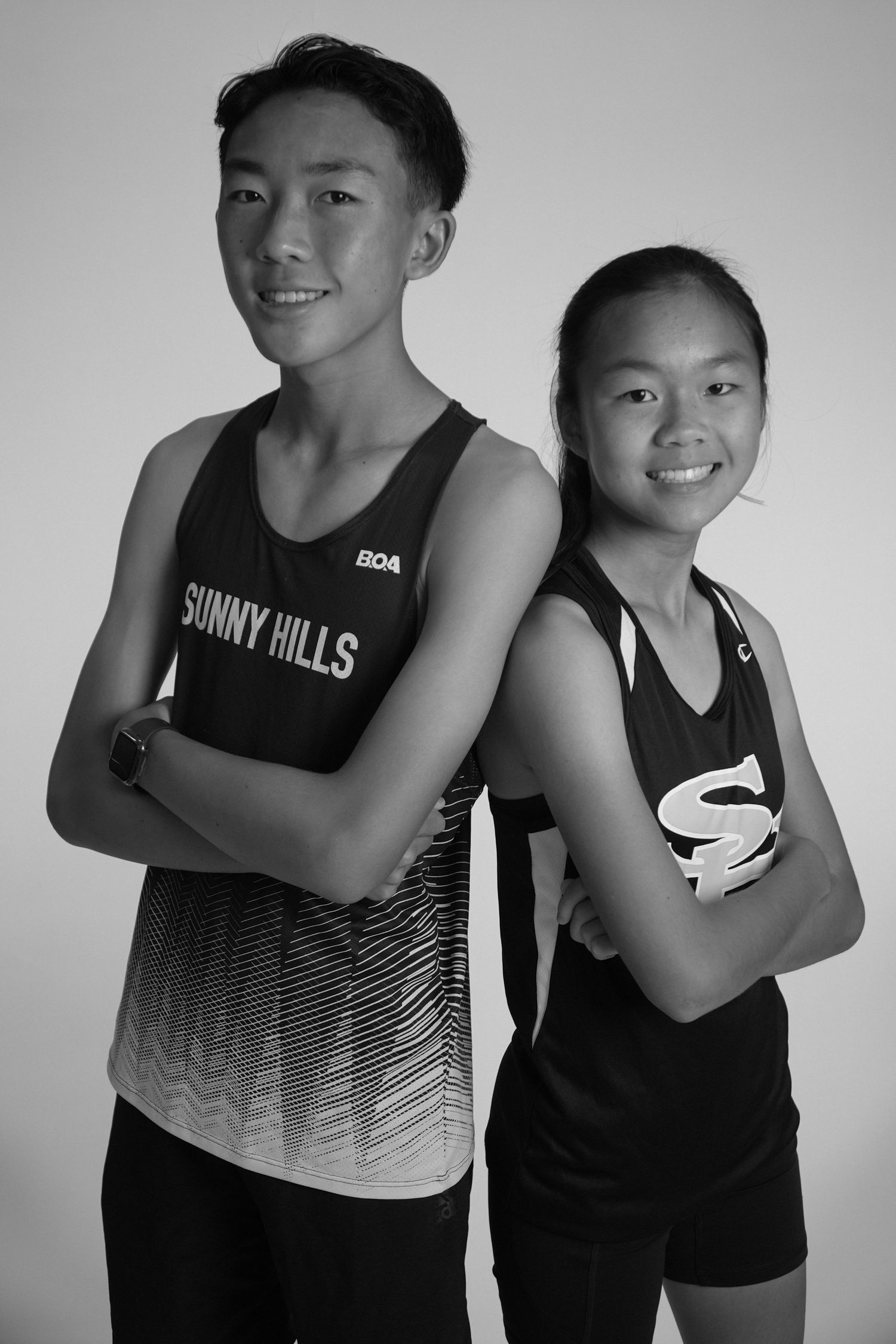 Two high school cross country athletes in uniform pose for sports team portraits in Fullerton, CA.