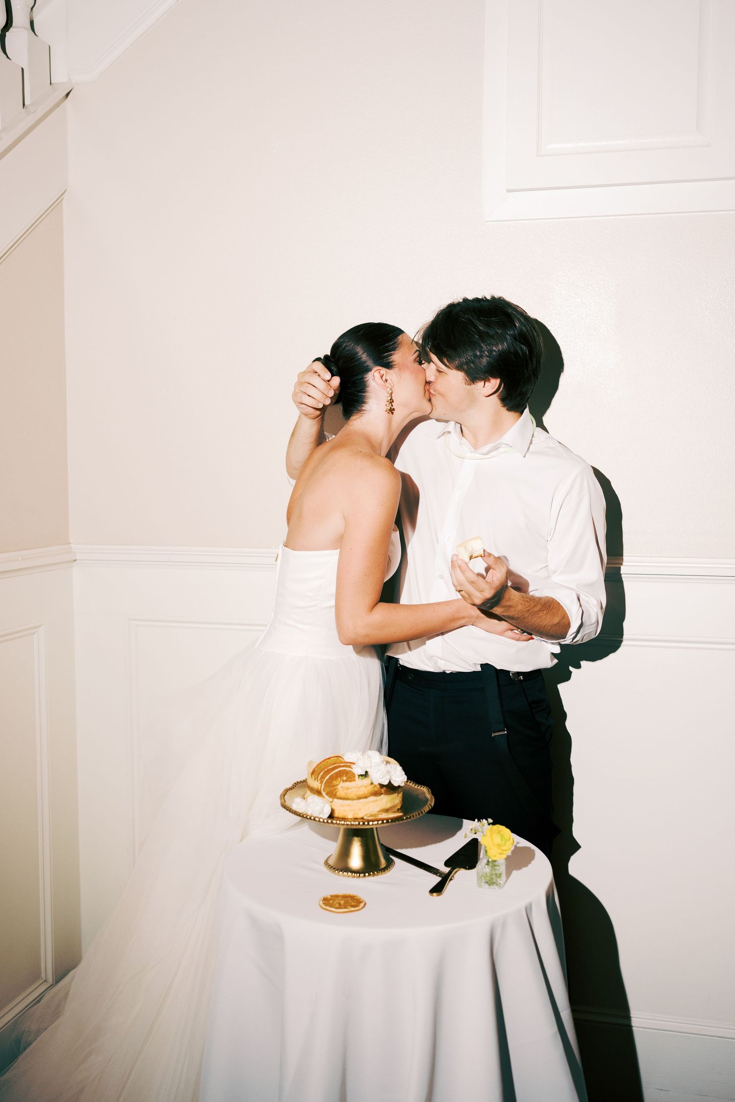 A wedding cake cutting moment with a couple sharing an intimate moment at their reception.