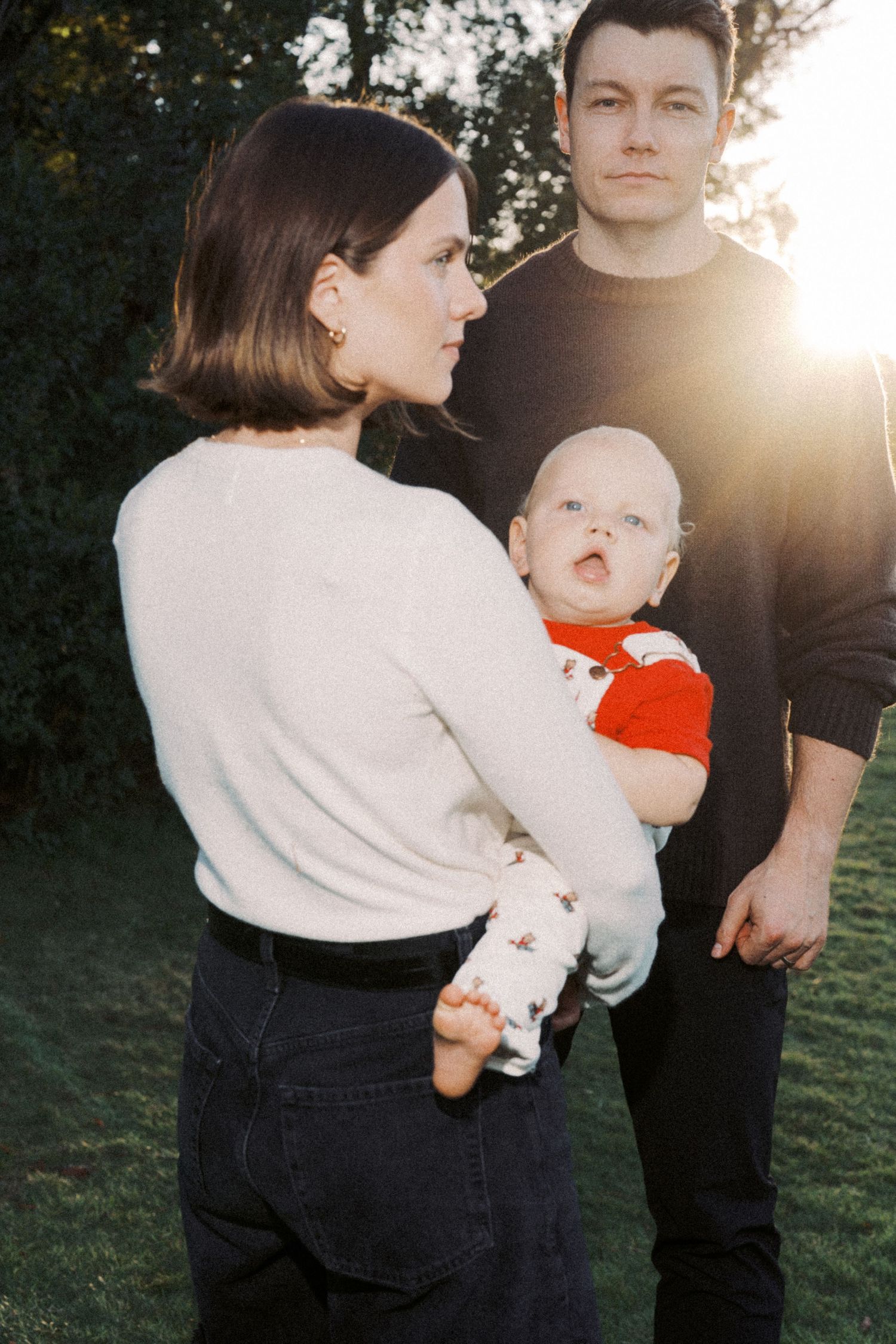A family poses together outdoors in a series of candid shots during golden hour sunlight.