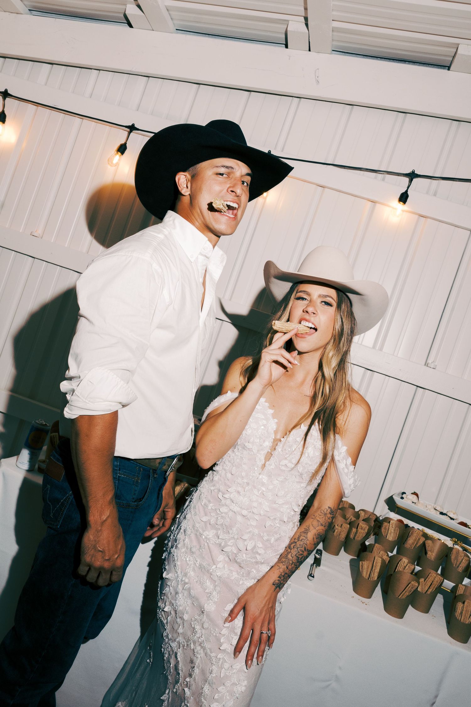 A joyful reception moment with cowboy hats and laughter on the dance floor.