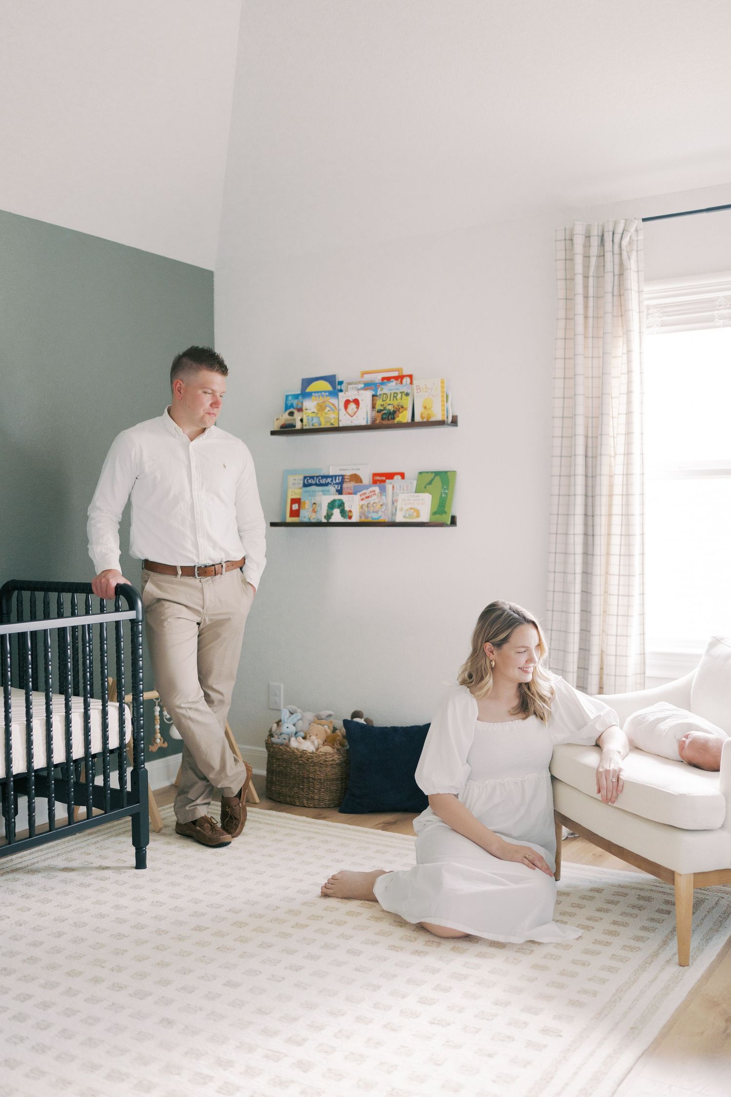 Nursery room interior with white and gray decor featuring crib and rocking chair.