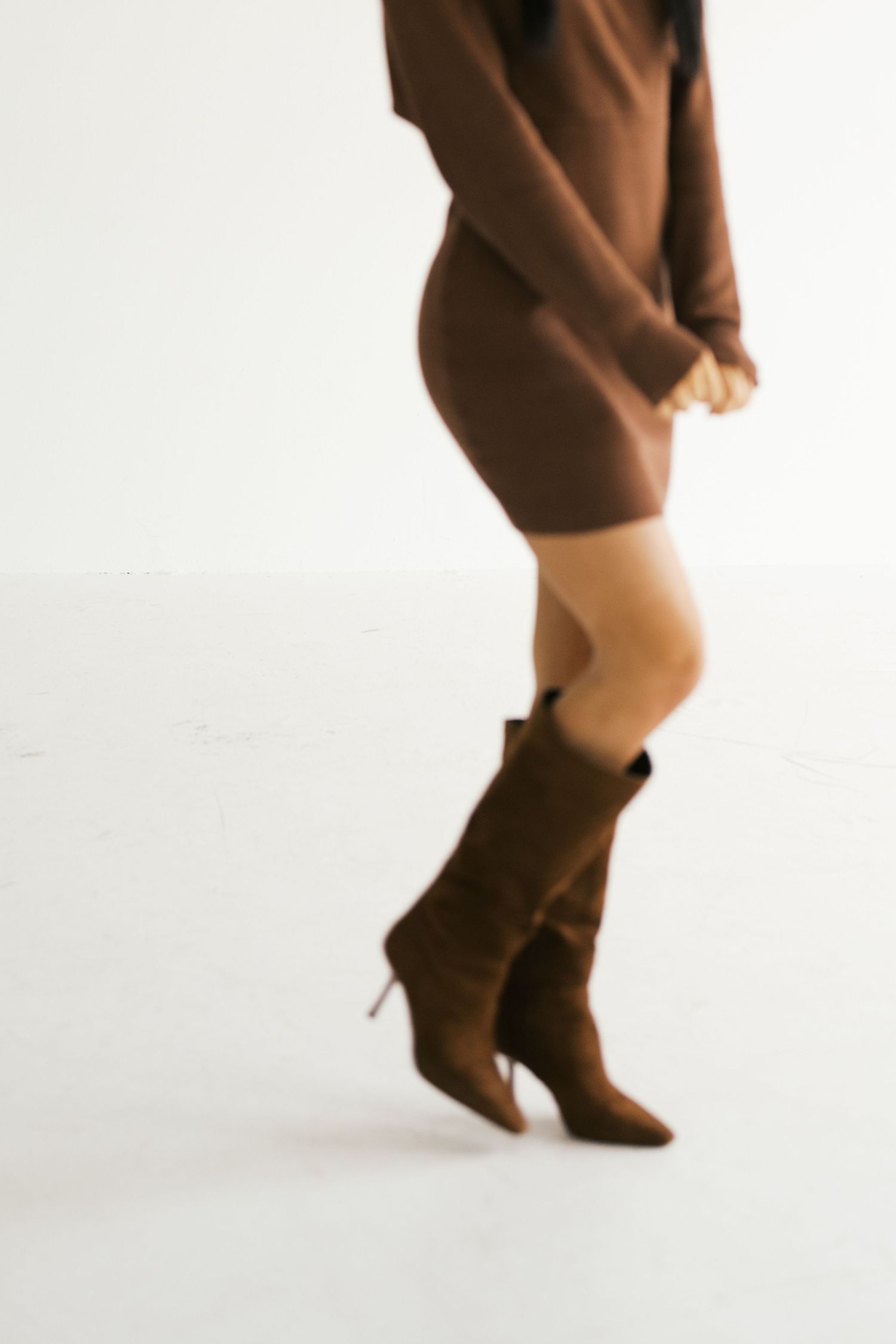 Close-up view of brown leather boots on a white background showing movement in a sequence.