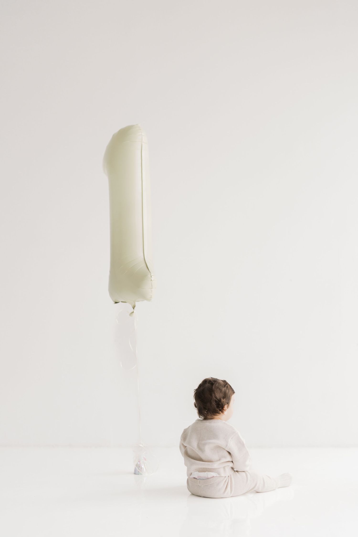 A white, inflatable object is floating in the air against a plain background.