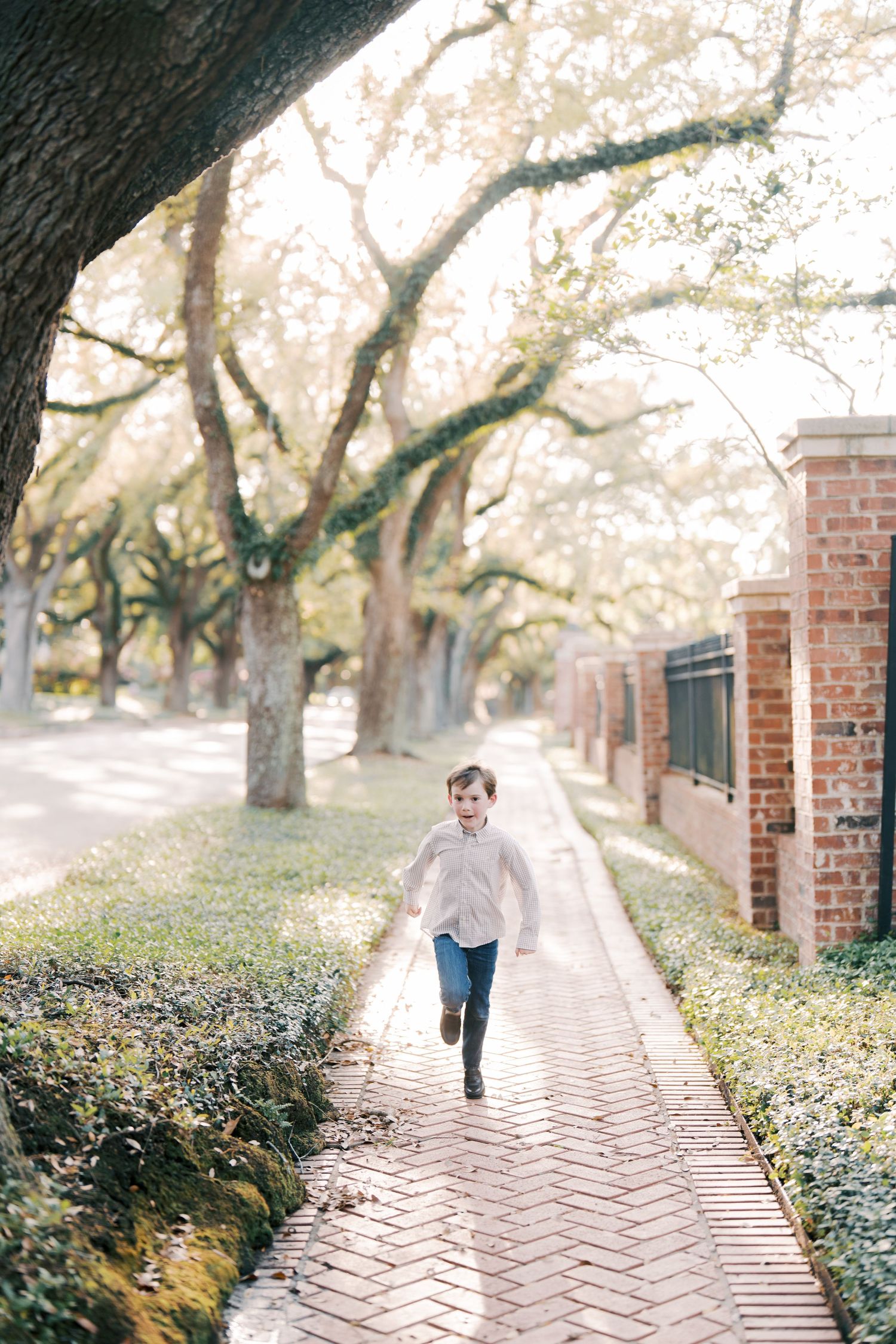 Person running along brick pathway lined with trees and brick columns.