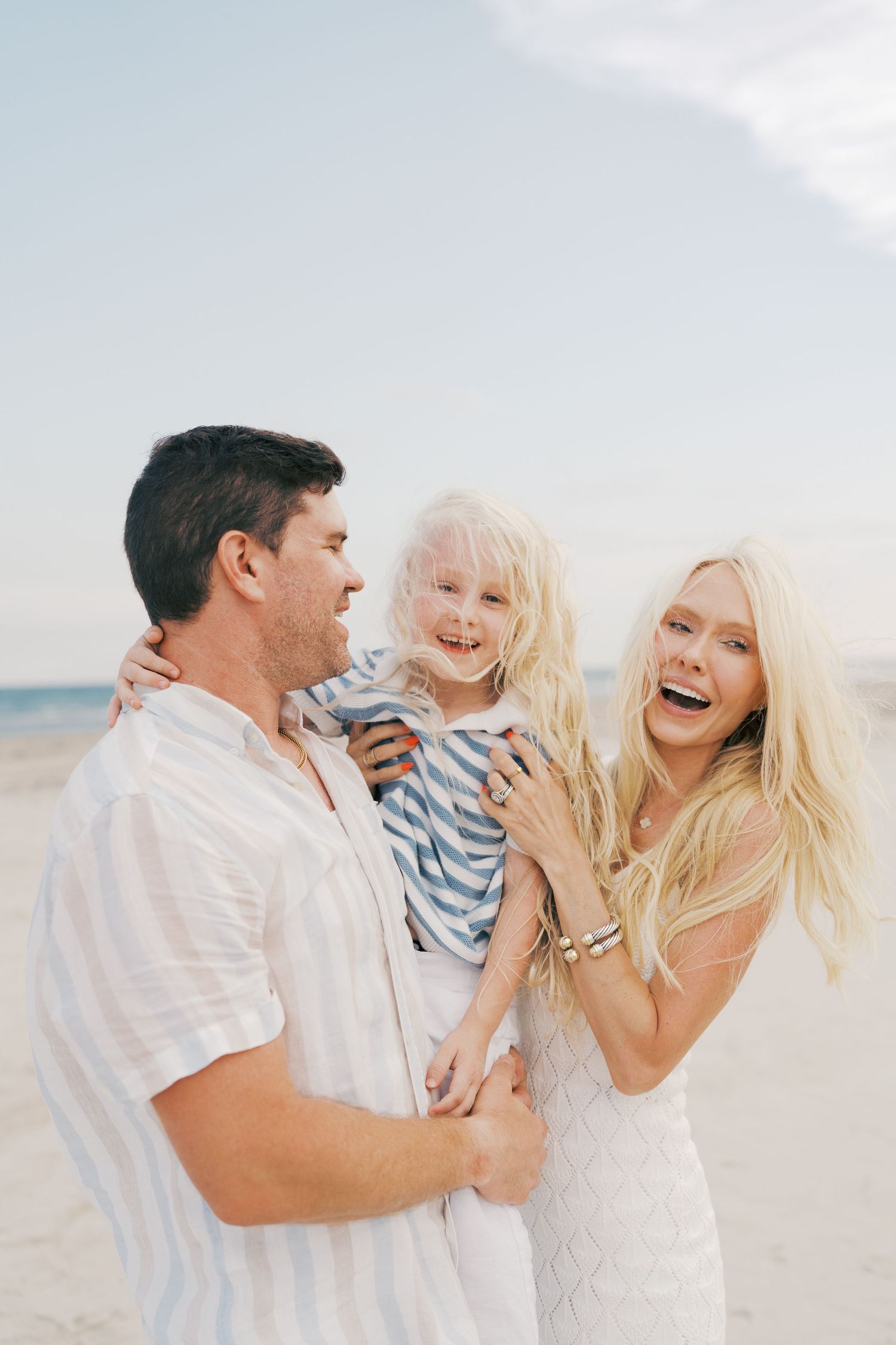 A happy family shares joyful moments together while playing on a sunny beach.