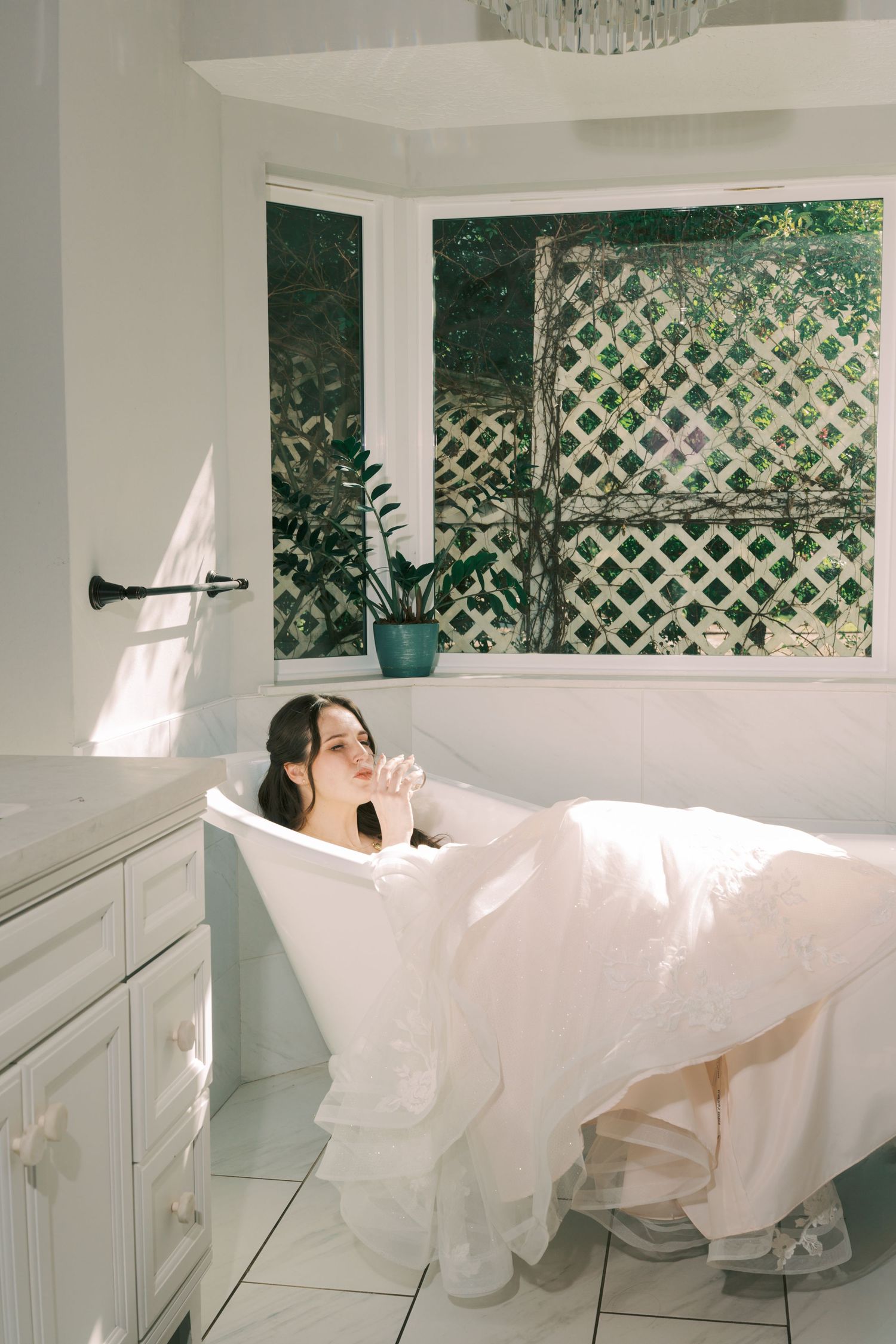 White curtains billow in a gentle breeze through latticed windows of a bright sunlit room.