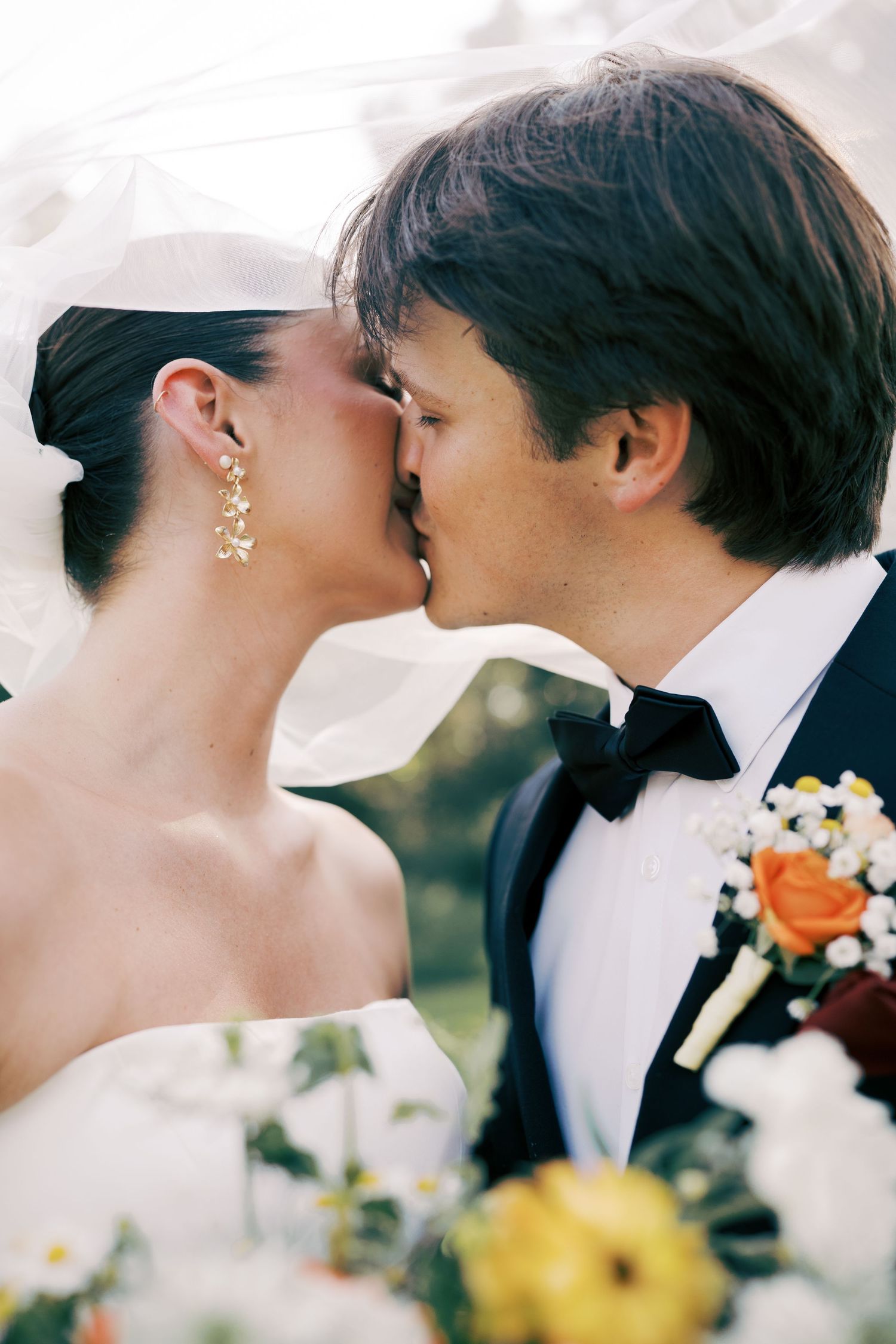 Romantic wedding couple shares an intimate moment among flowers during their special day.