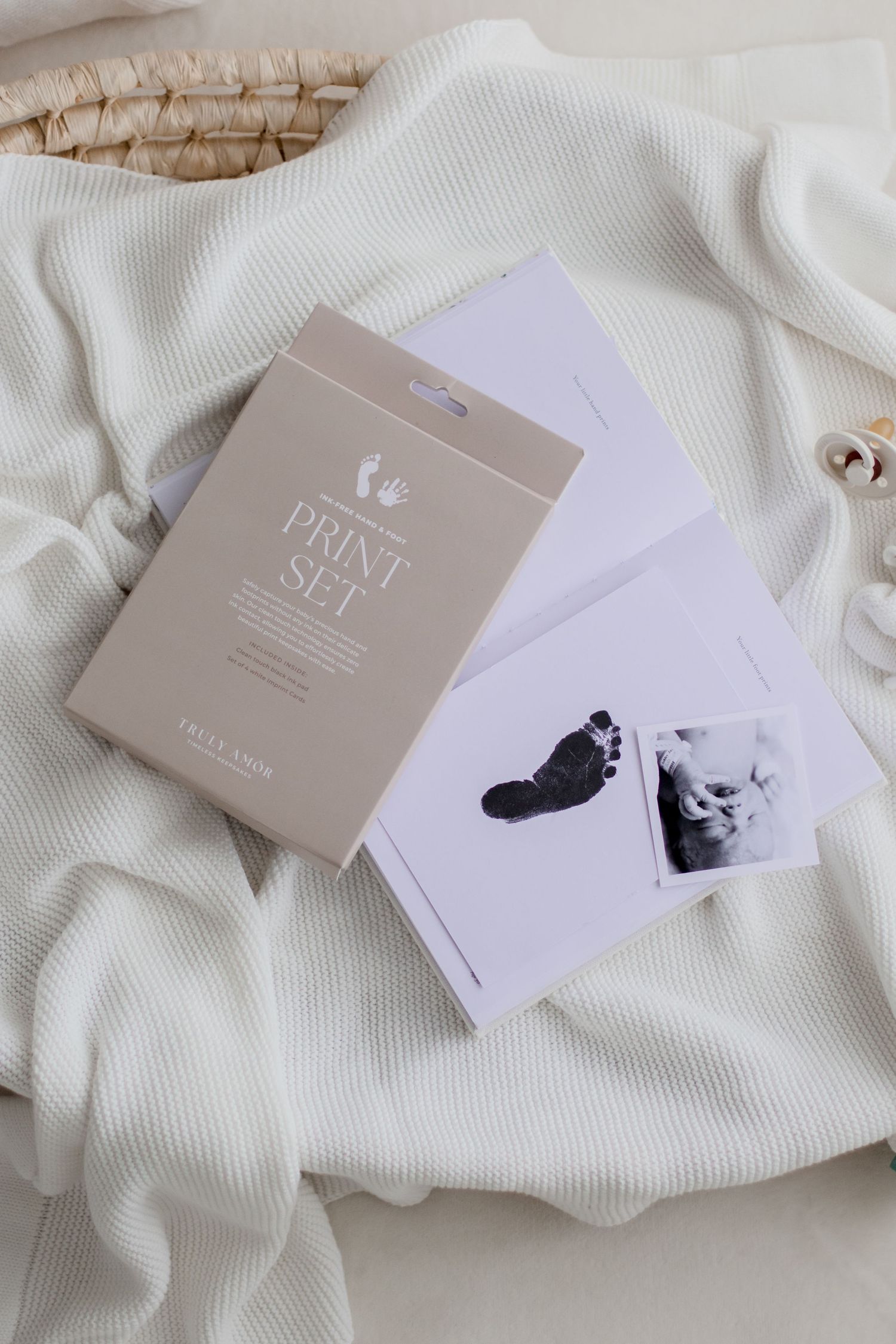Business cards and branding materials in neutral gray and white tones displayed on textured fabric background.