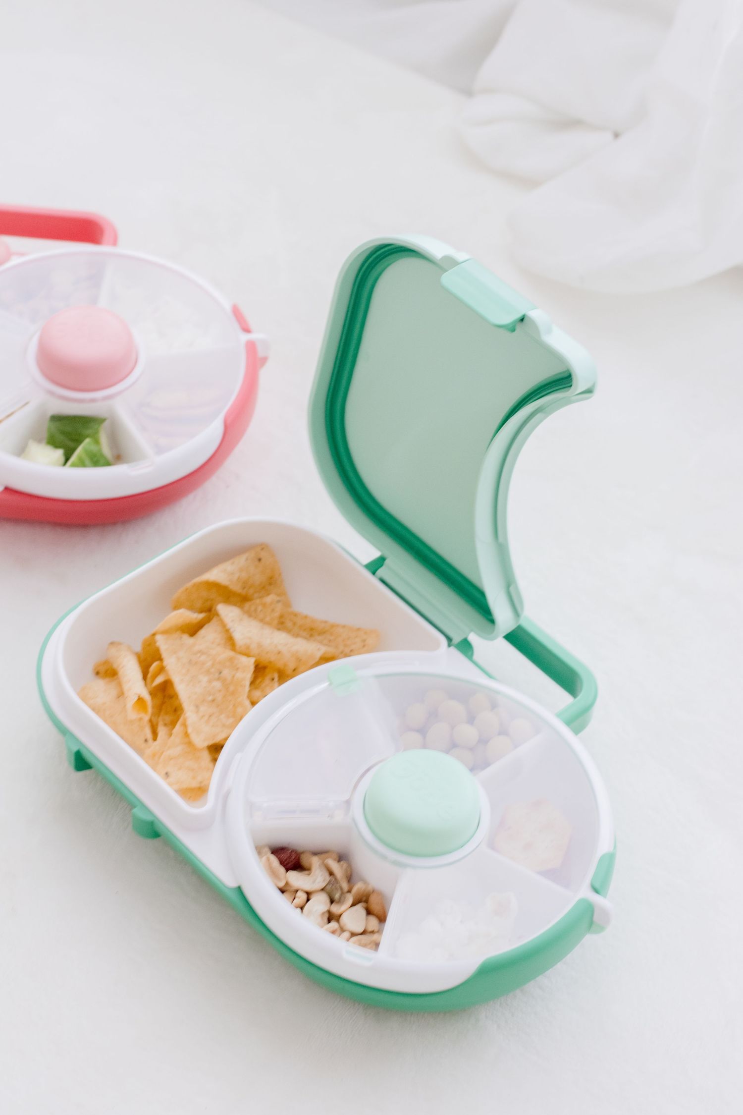 Divided snack container with tortilla chips and compartments in mint green and pink colors.