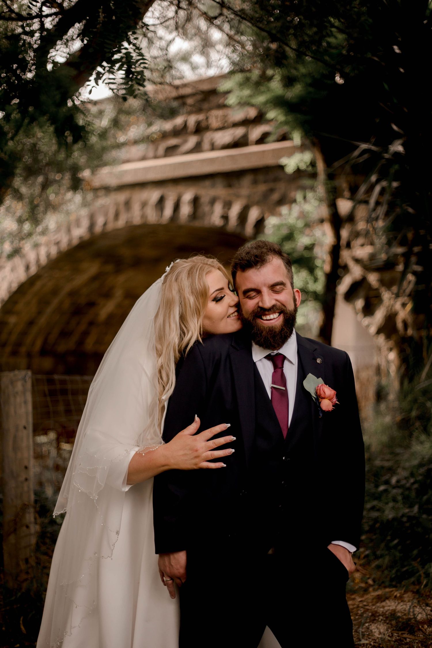 Series of romantic outdoor wedding photos showing candid moments between newlyweds near a brick archway.