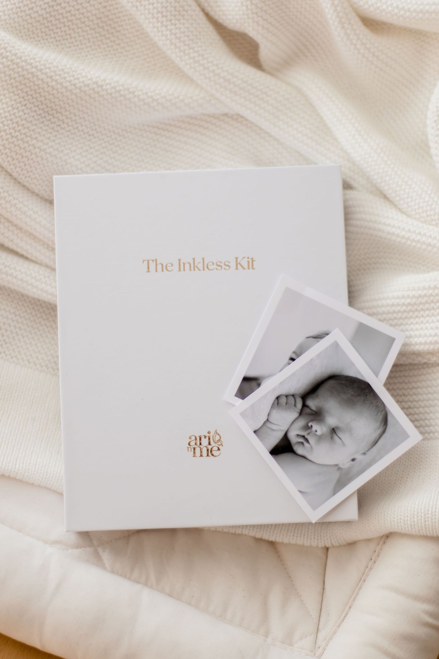 White Inkless Kit box by Arie and Me with black and white newborn baby photos on a cream blanket.