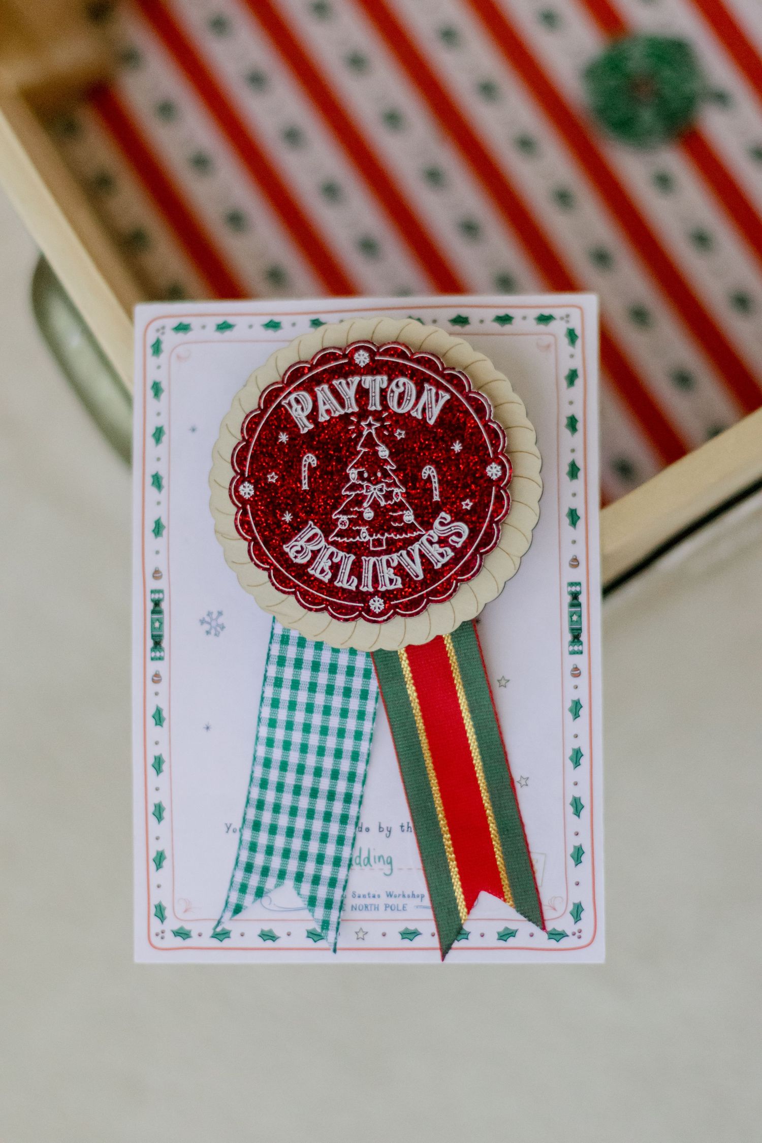 Christmas name tags with red and green ribbons featuring gingham patterns and festive designs.