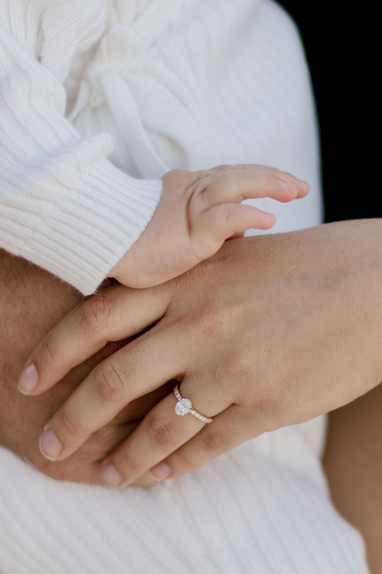 Close-up sequence of hands connecting in an engagement ring proposal with a sparkling solitaire diamond ring.