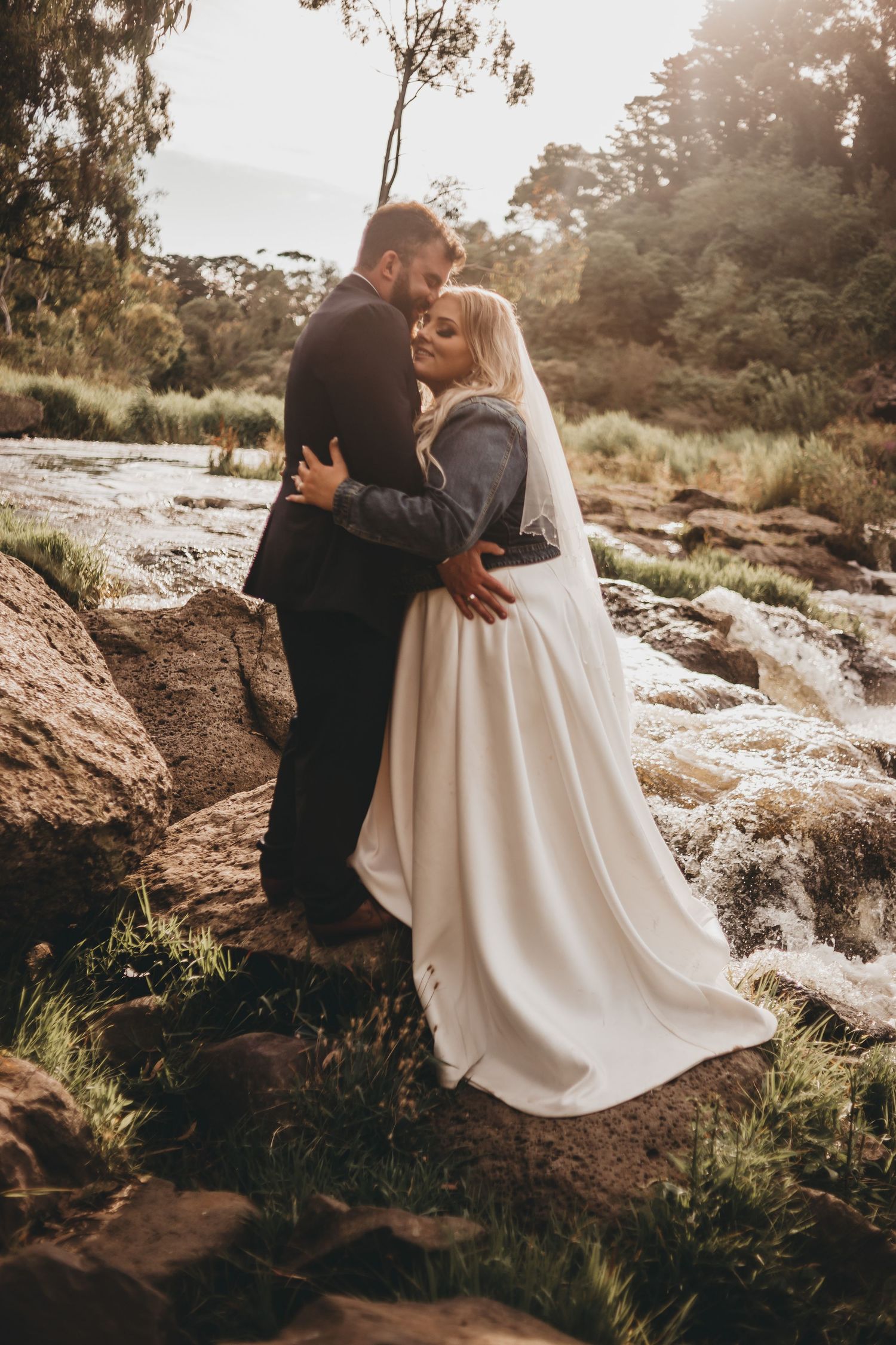 Romantic wedding photo series on rocky terrain with flowing white dress and moody lighting in nature setting.