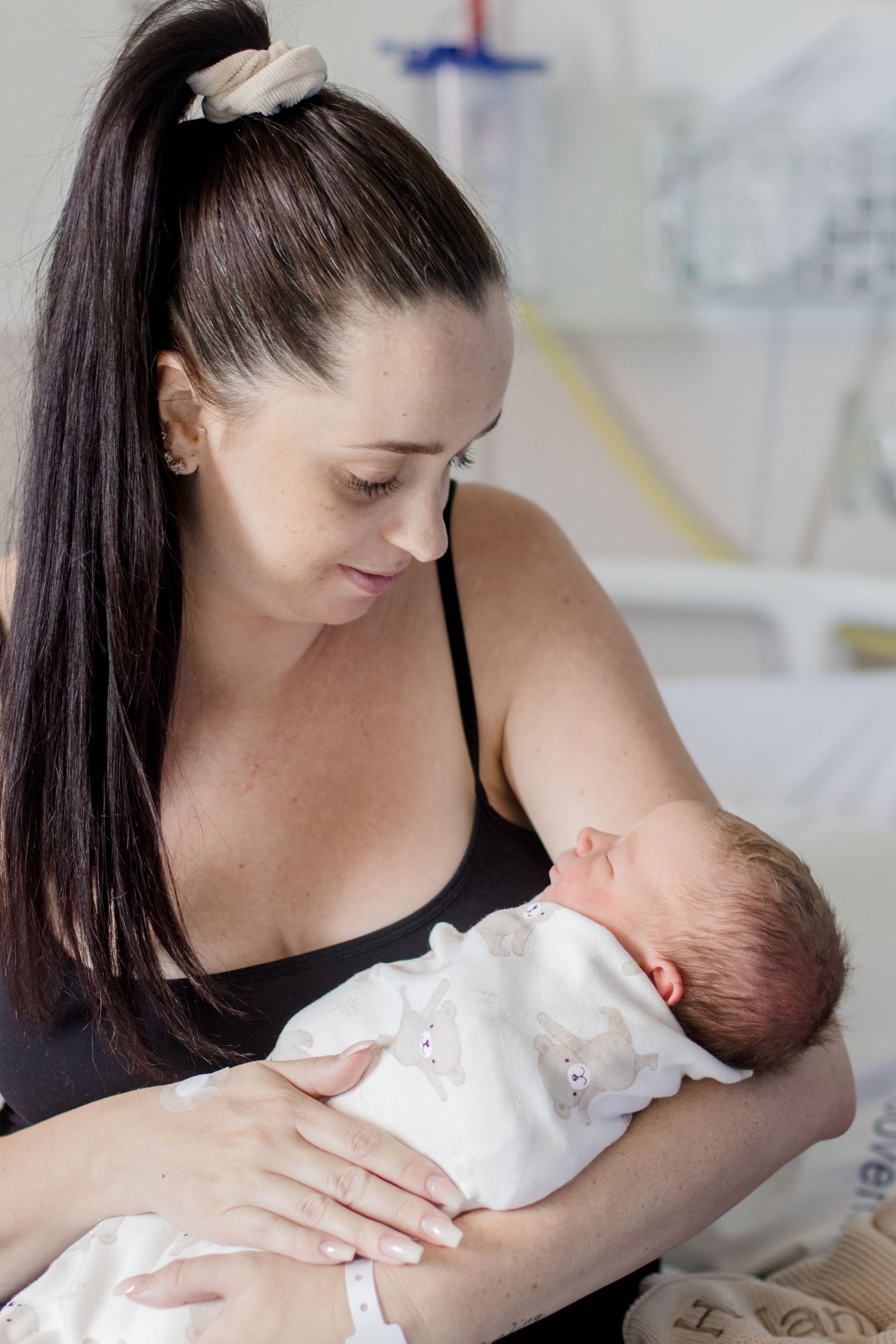 Intimate nurturing moment with newborn in white clothing.