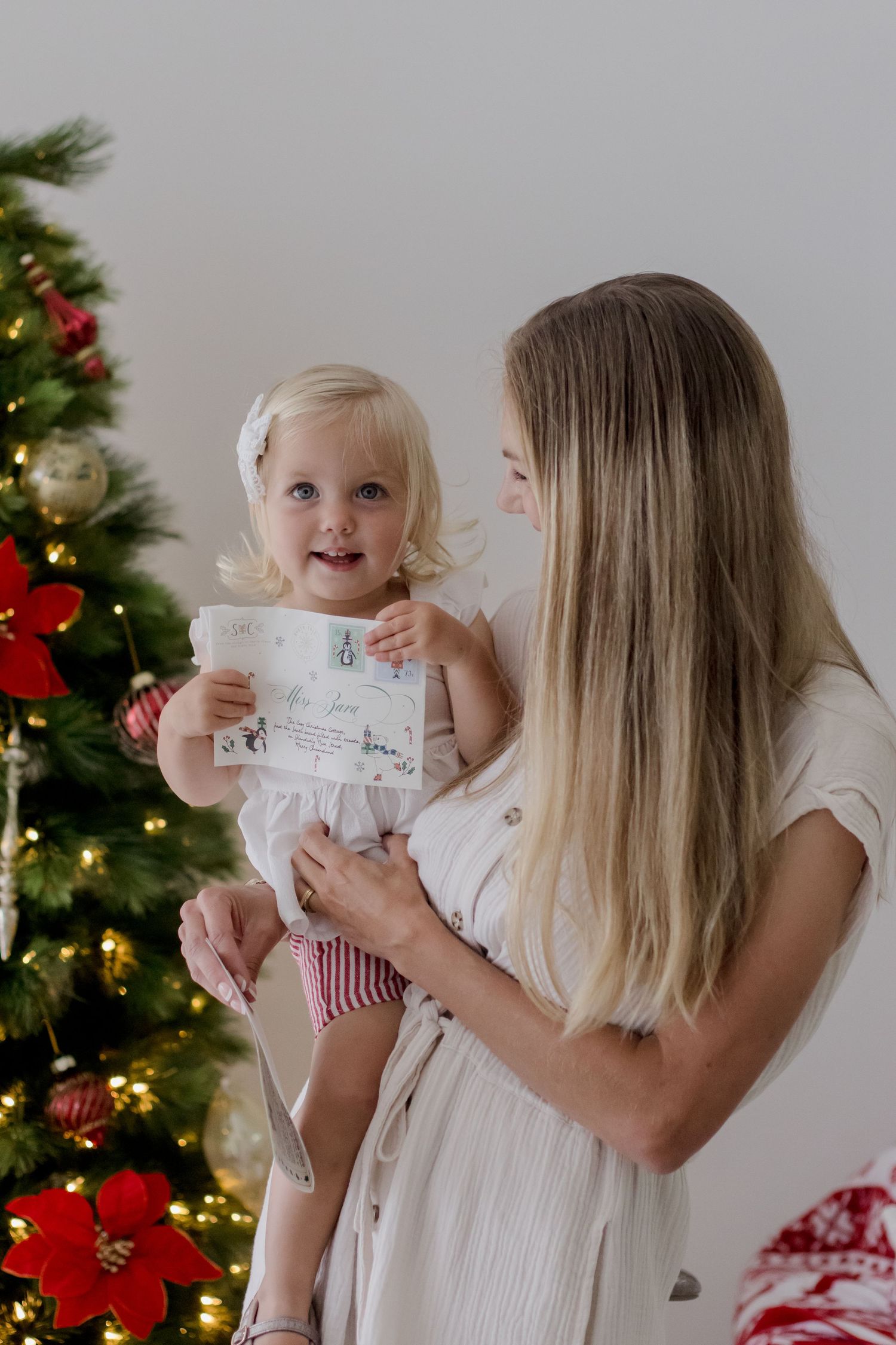 A series of photos showing a letter being held up against a Christmas tree background with twinkling lights.