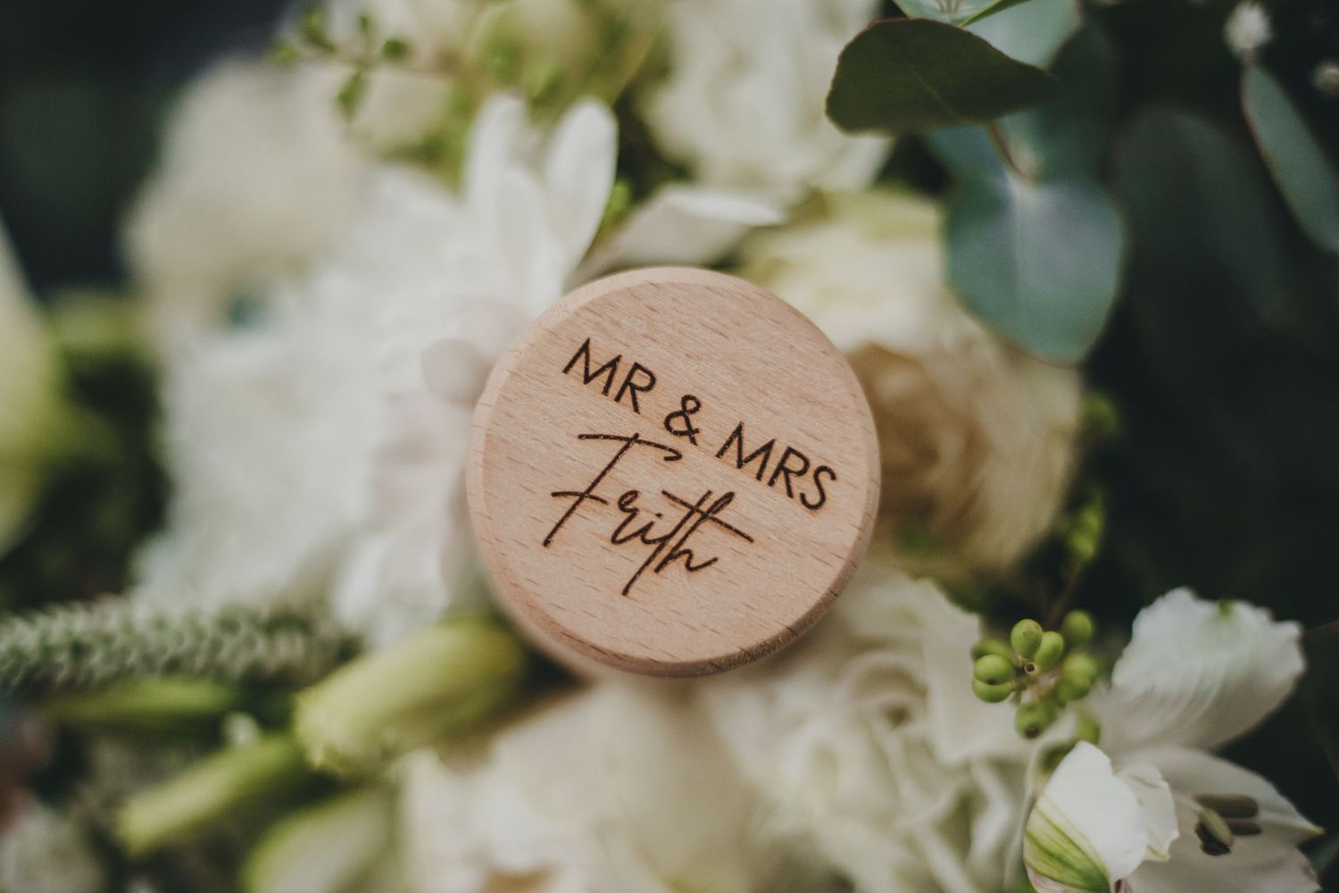Wedding ceremony decorations featuring rustic wooden signs with 'Mr & Mrs' text and delicate white floral arrangements.